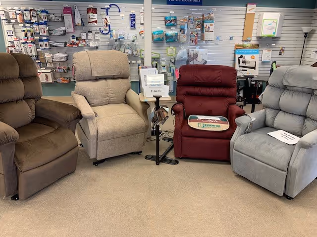 Row of four upholstered recliners in a showroom with wall accessories behind.