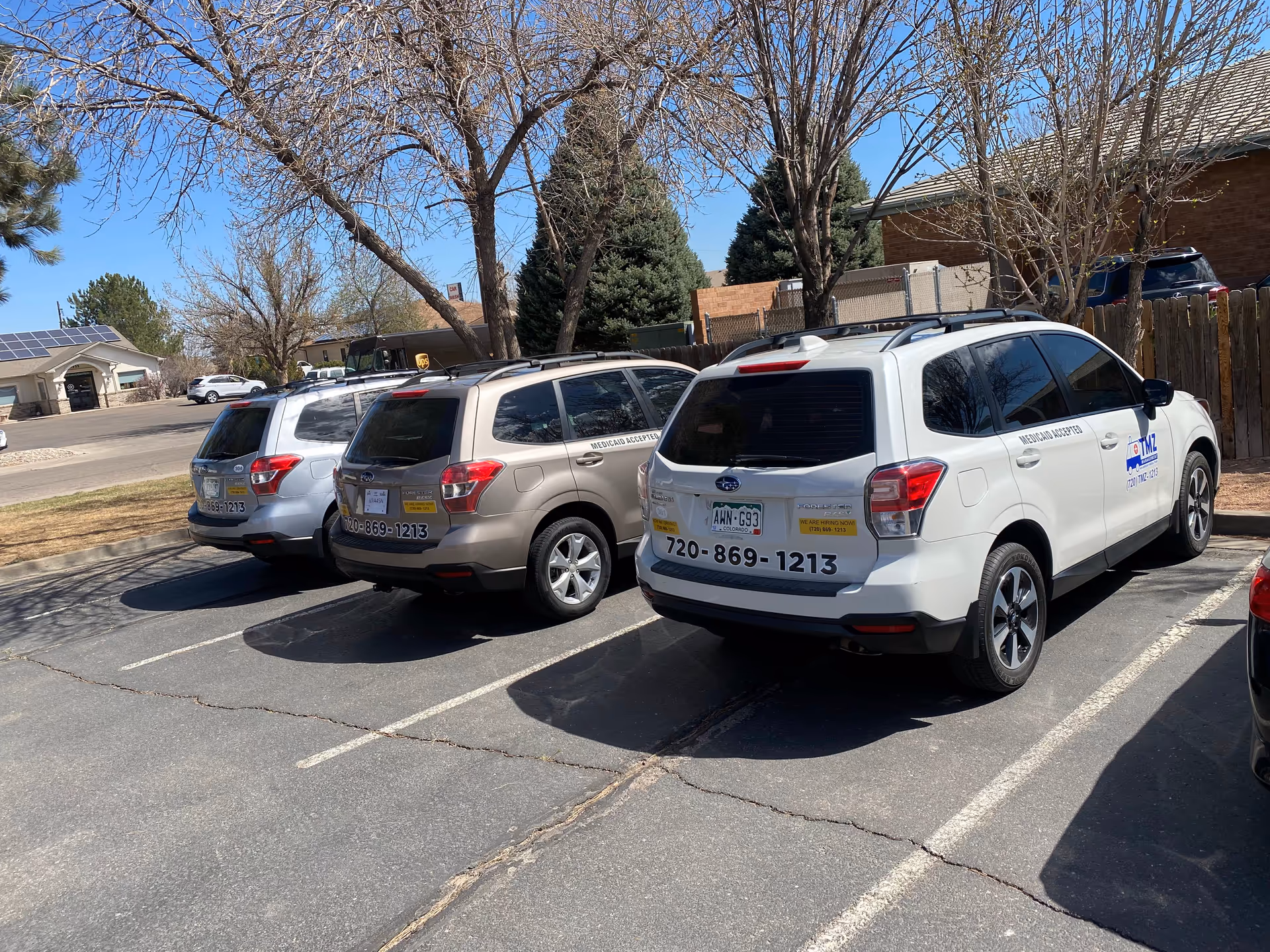 Several TMZ Medical Transportation vehicles parked in a suburban parking lot.