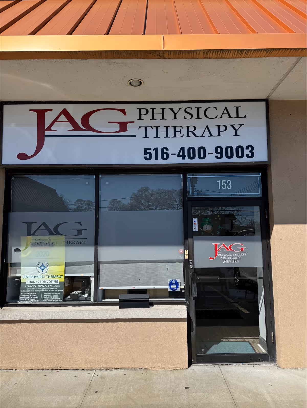 Storefront sign for JAG Physical Therapy with large window and glass door