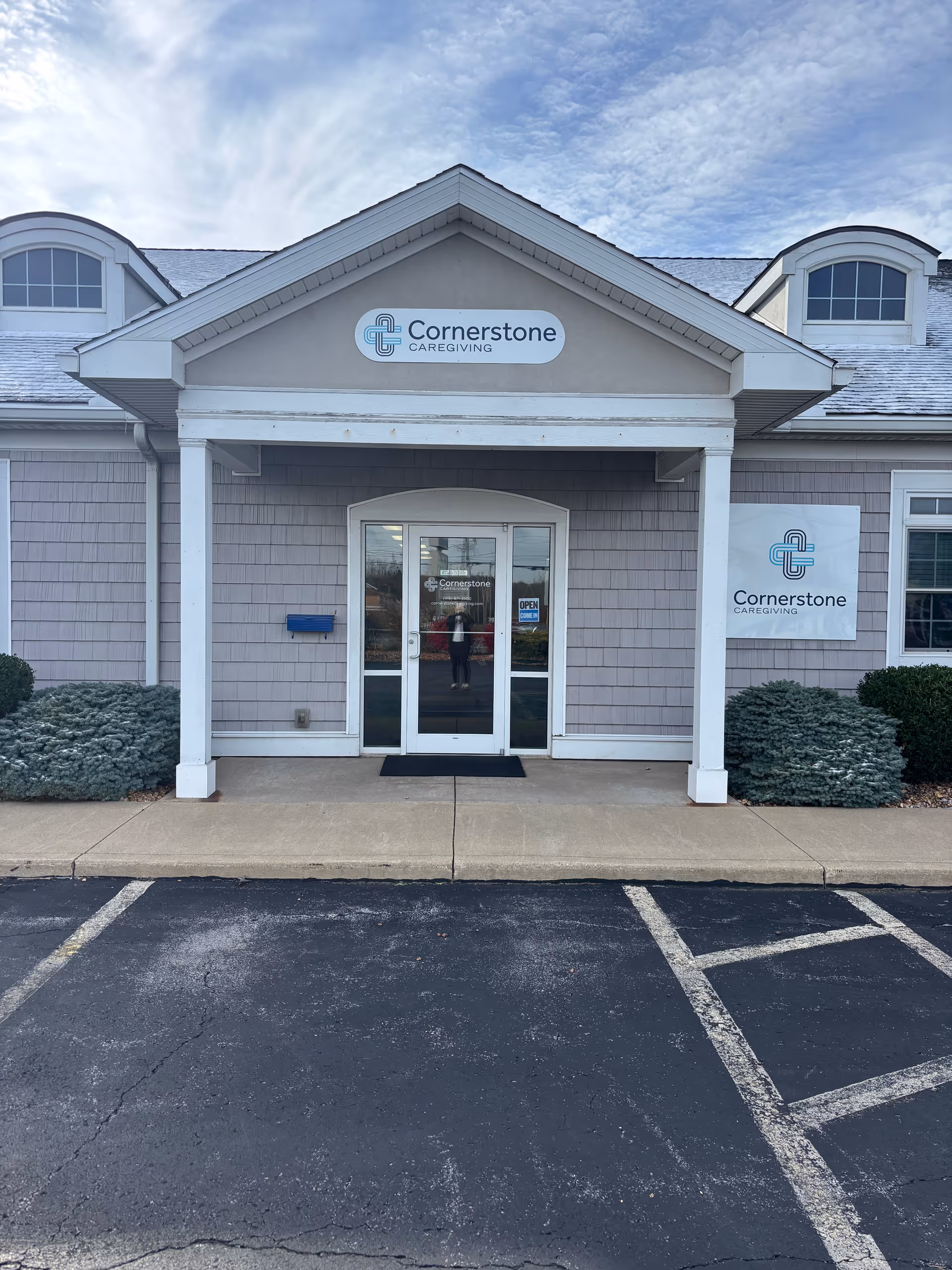 Front exterior of Cornerstone Caregiving building with double doors and signage.