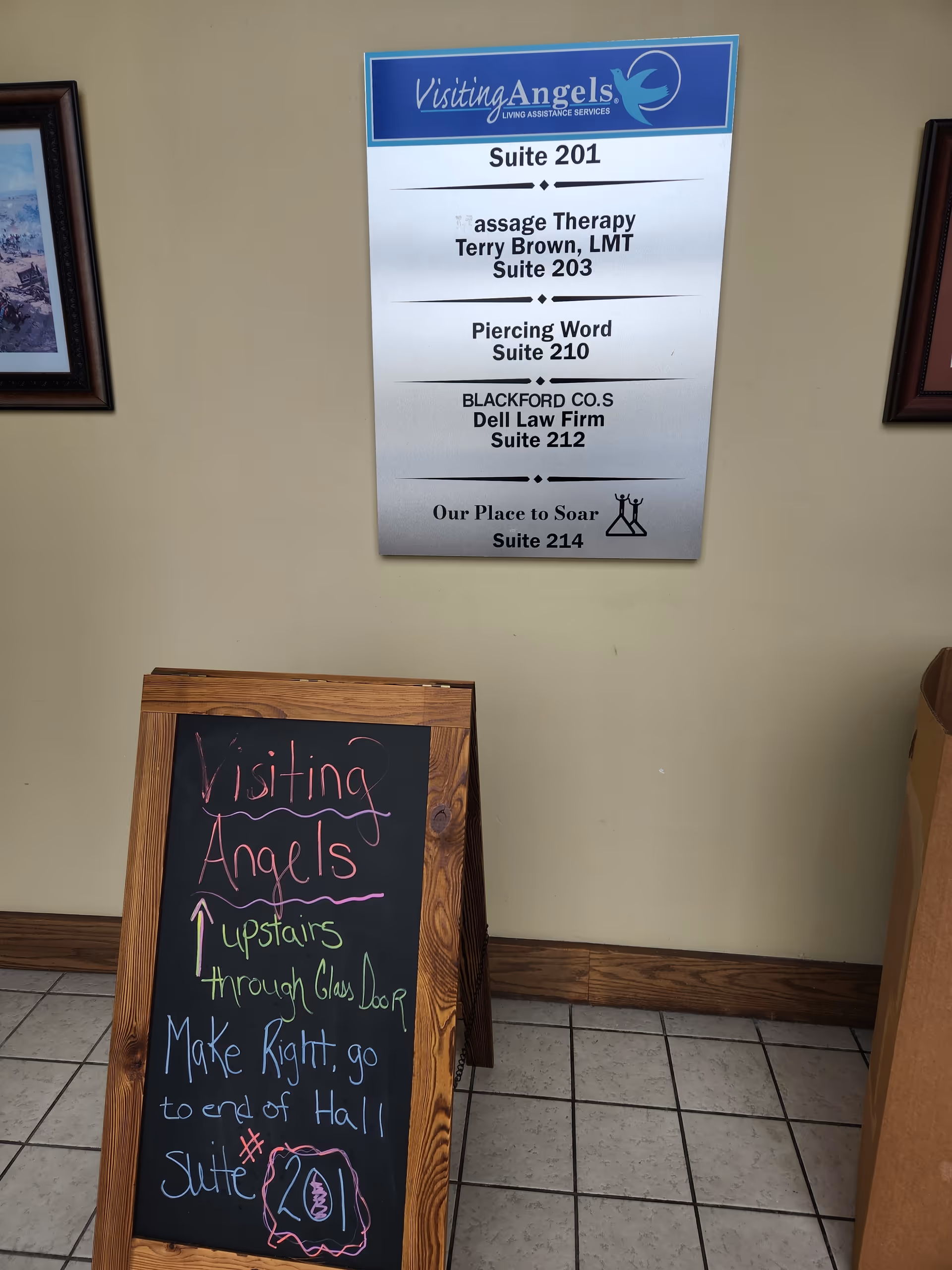 Interior hallway featuring Visiting Angels directory sign and a chalkboard with directions.
