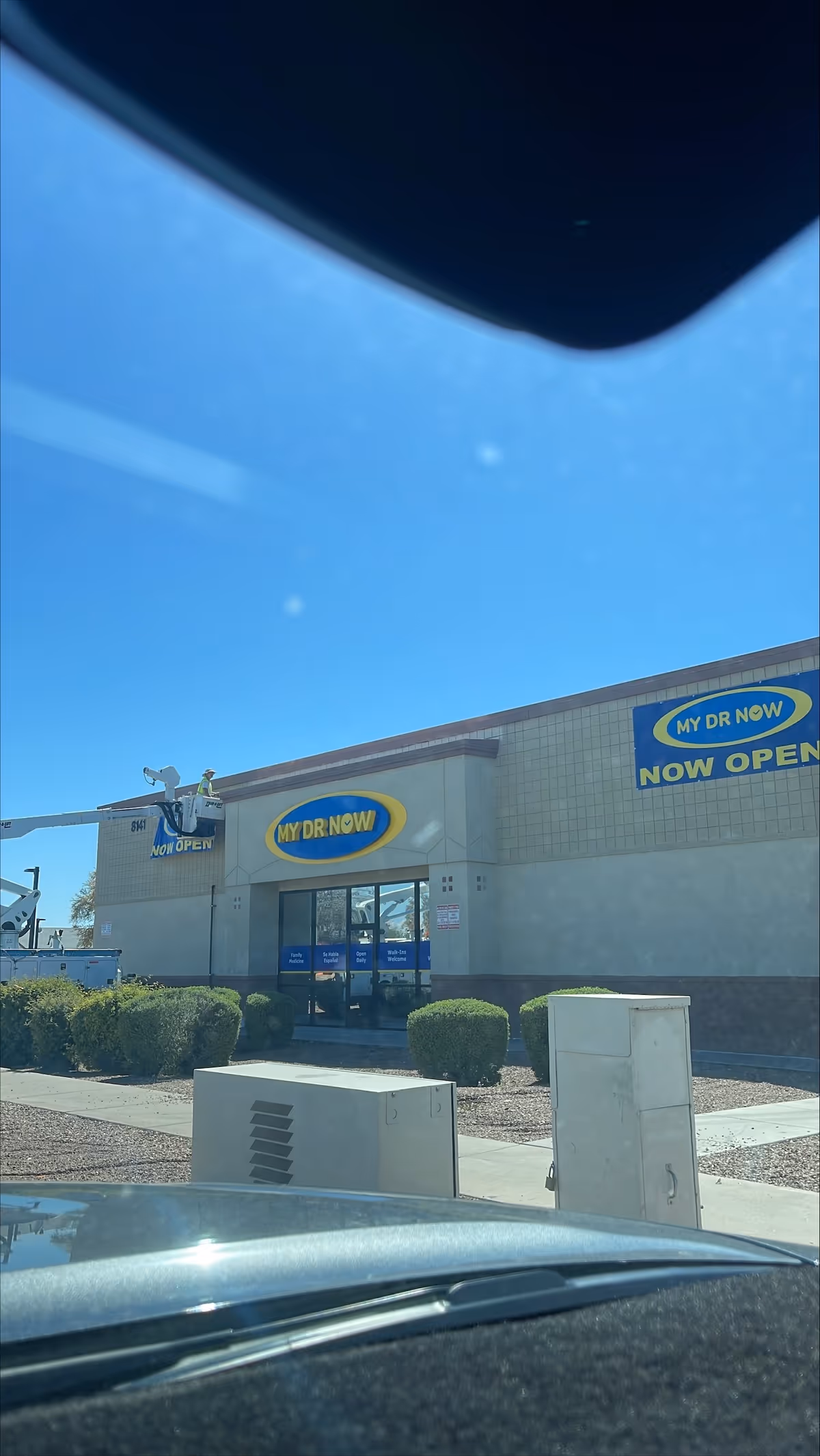 Exterior view of MY DR NOW facility with banners and glass entrance doors.