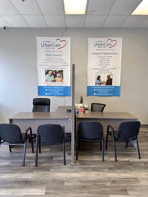 Interior reception area with two desks, chairs, and UrbanCare banners.