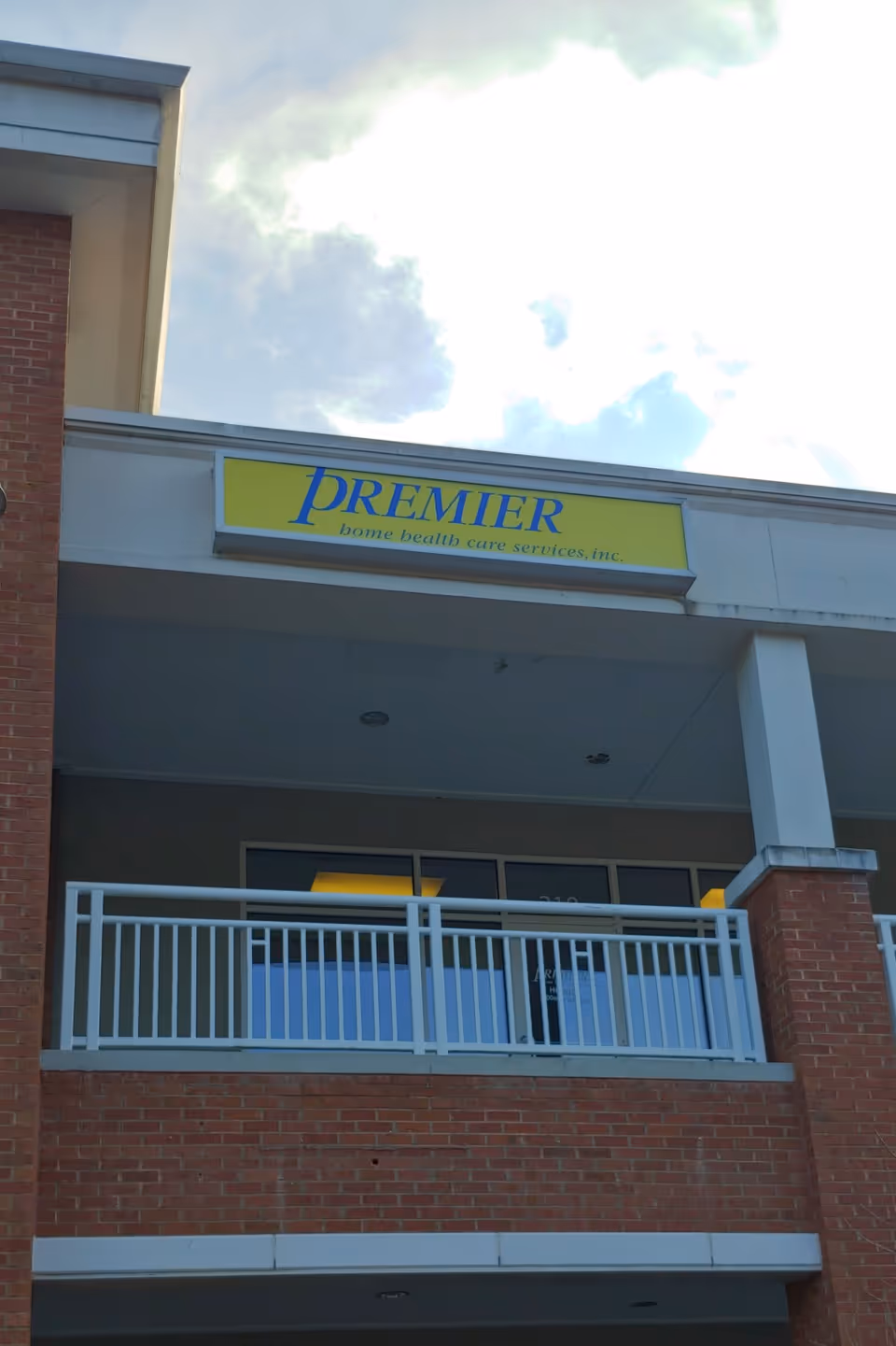 Front view of Premier Home Health Care Services, Inc. building with yellow sign.