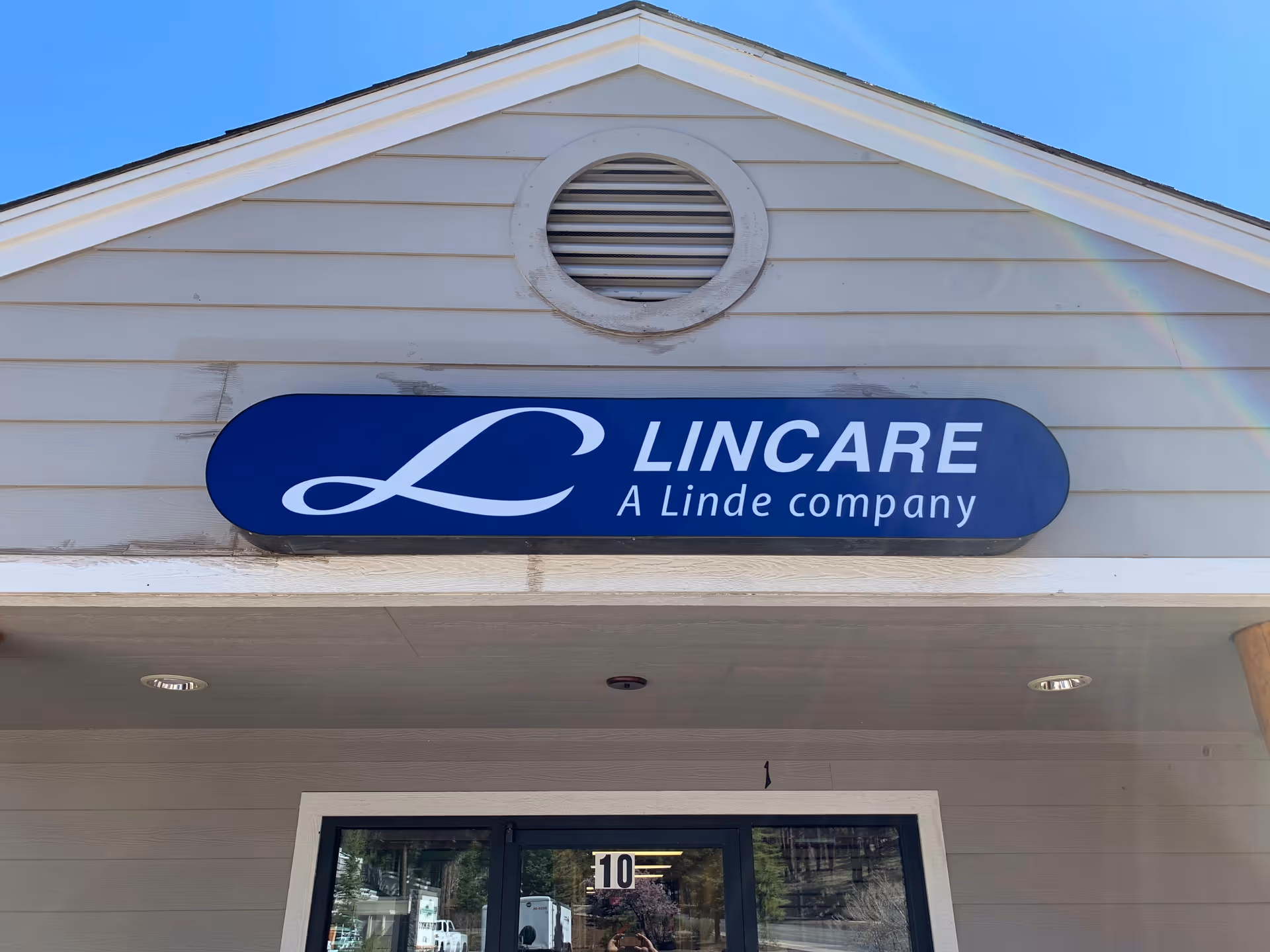 The building front features a LINCARE sign above the entrance under a blue sky.