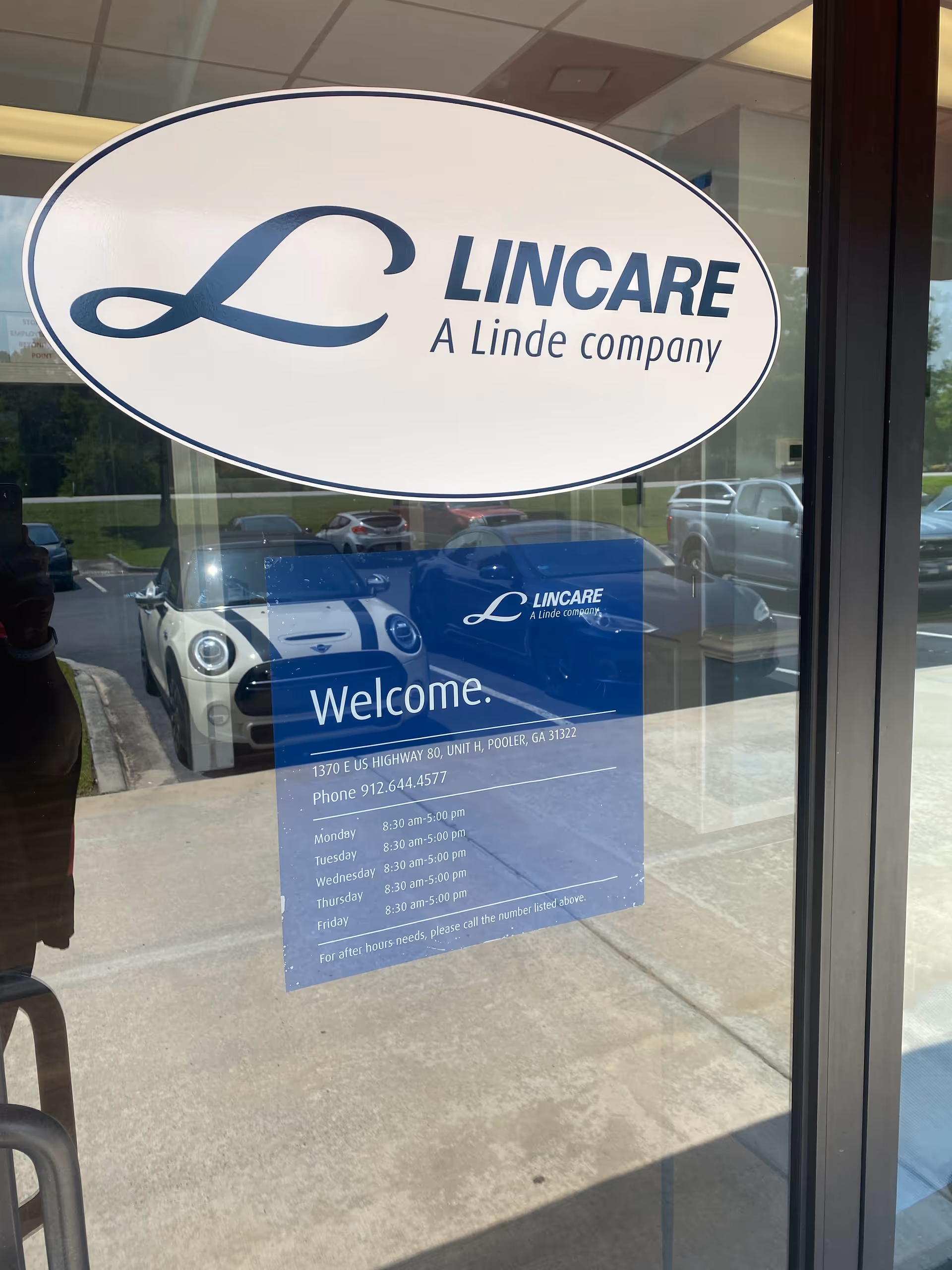 Large Lincare sign on glass door with Welcome board and parking lot reflections