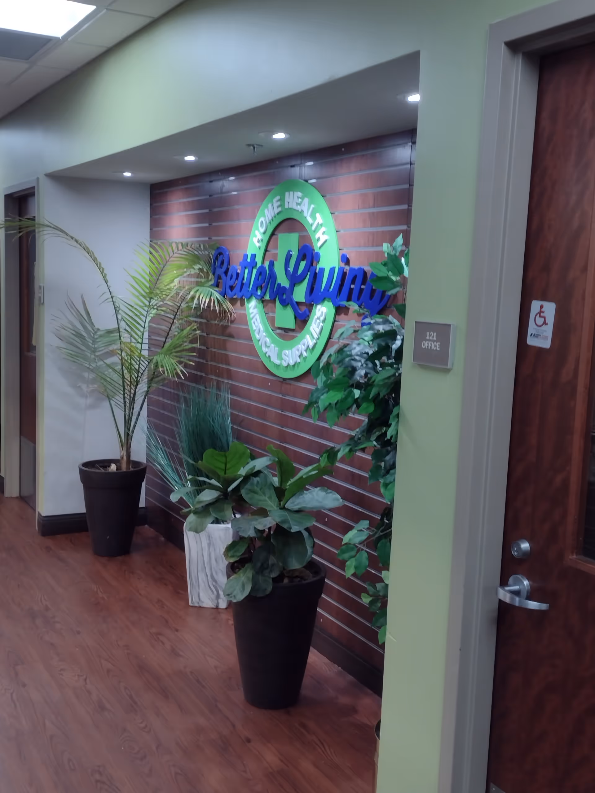 Interior hallway with green walls, plants, and a Better Living Home Health sign.