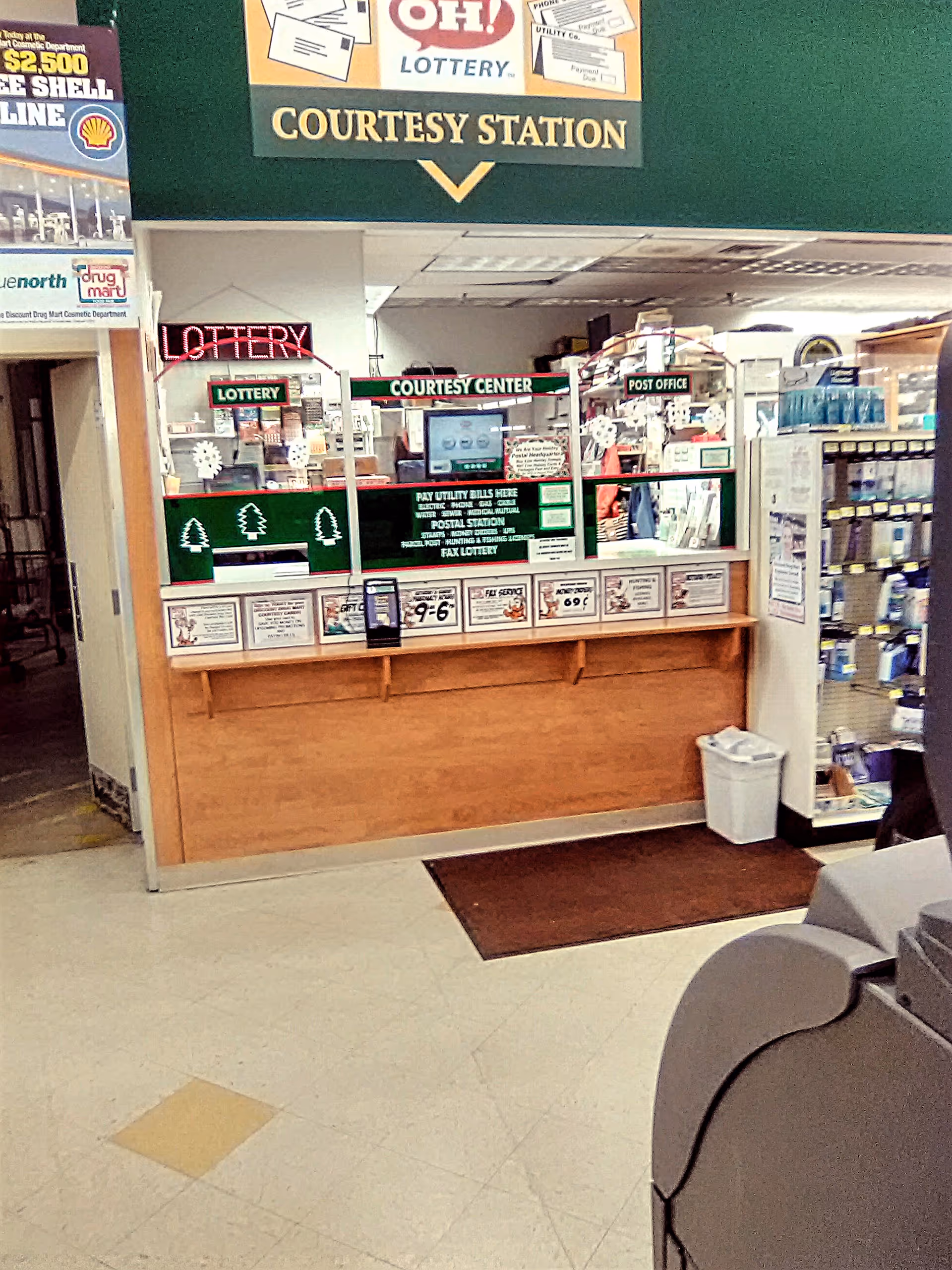 Interior view of Discount Drug Mart courtesy station with lottery signs and service desk.