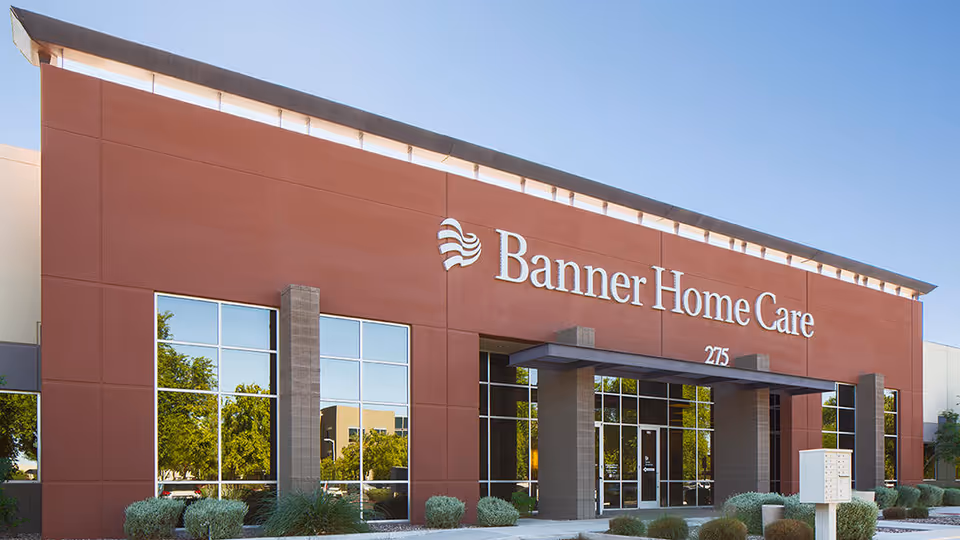 Exterior view of Banner Home Care building with red facade and glass entrance.