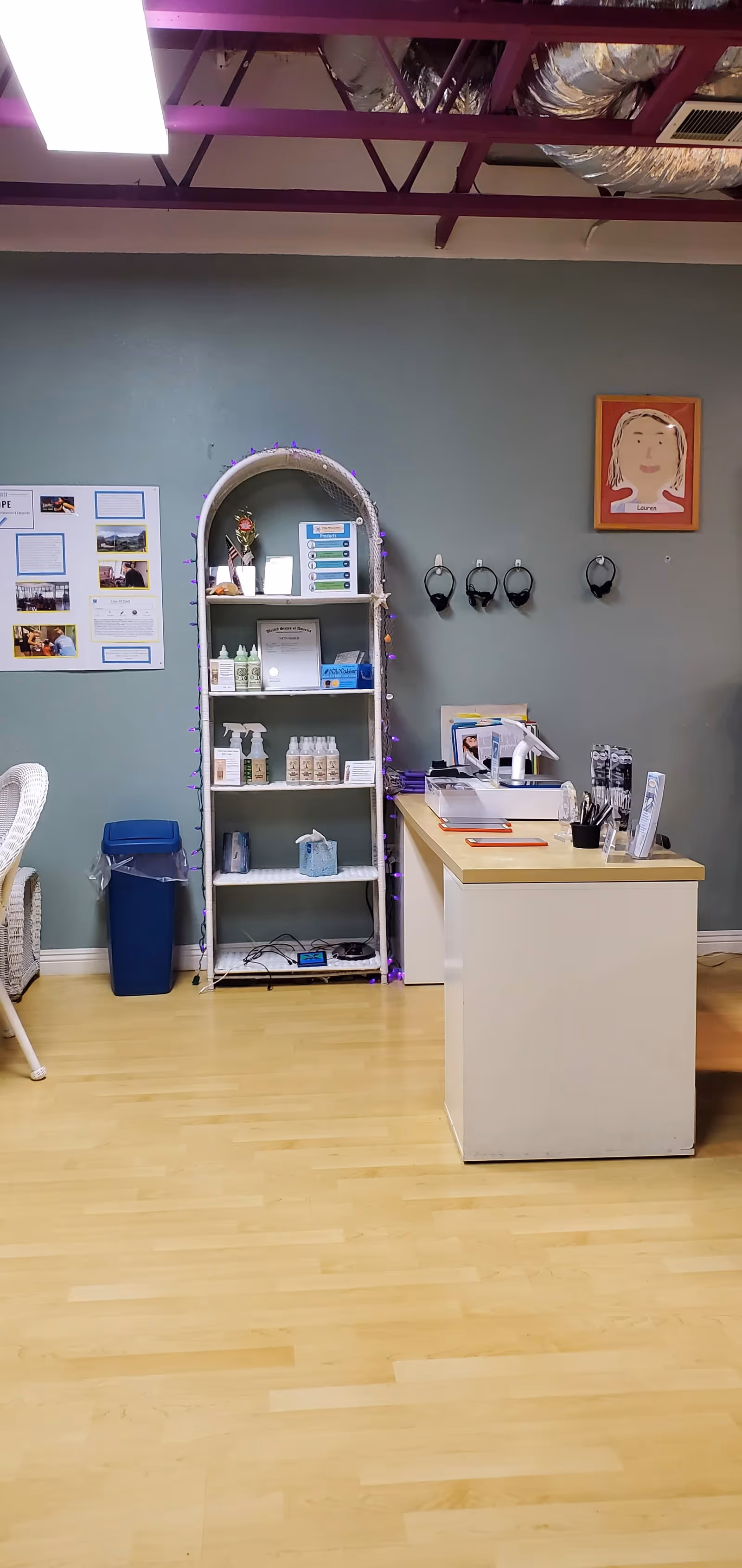 Reception desk with a shelf of lice treatment products in a calm treatment room.