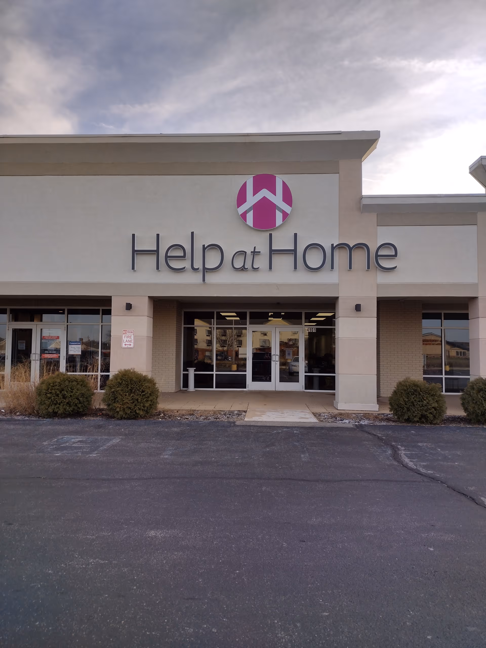 Exterior of Help at Home facility showing entrance and large sign on facade.