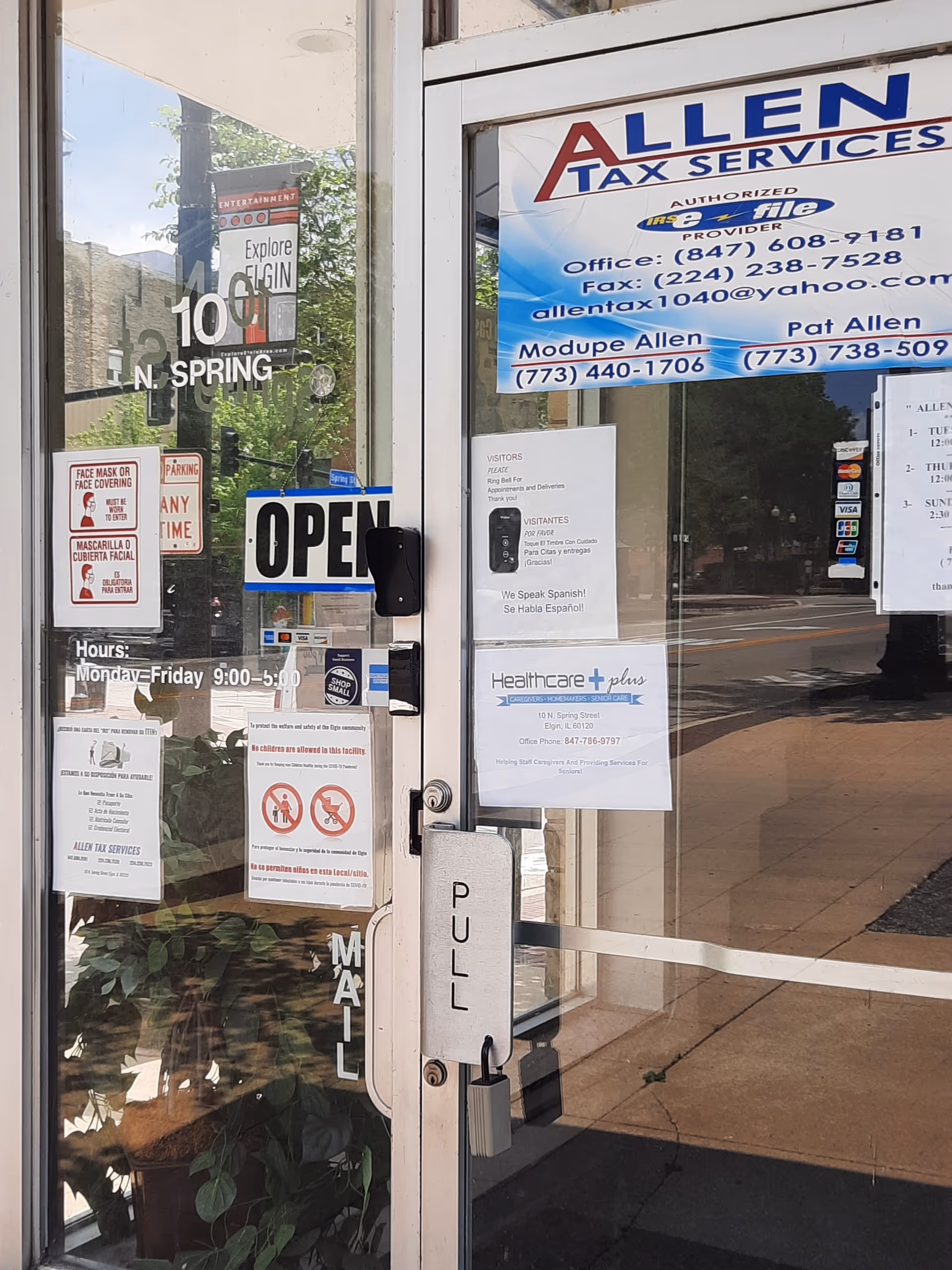 Glass storefront entrance for Healthcare Plus Caregivers with OPEN sign and posted notices.