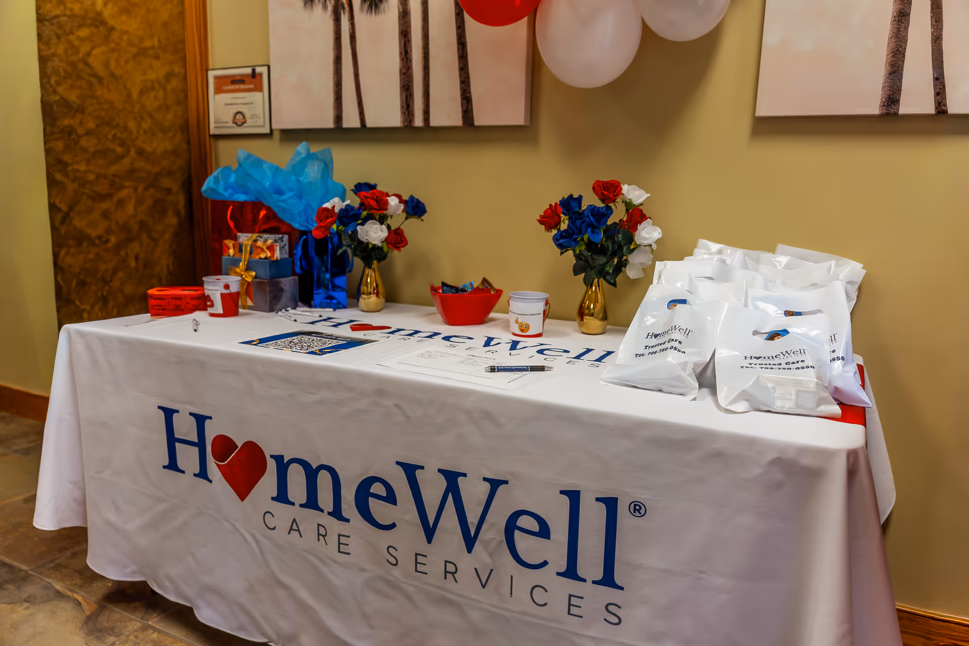 Indoor reception table with HomeWell Care Services branding and decorations.