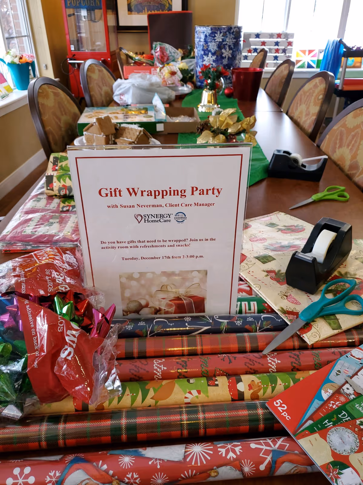 Indoor table at Synergy HomeCare with gift wrap supplies and a Gift Wrapping Party sign.