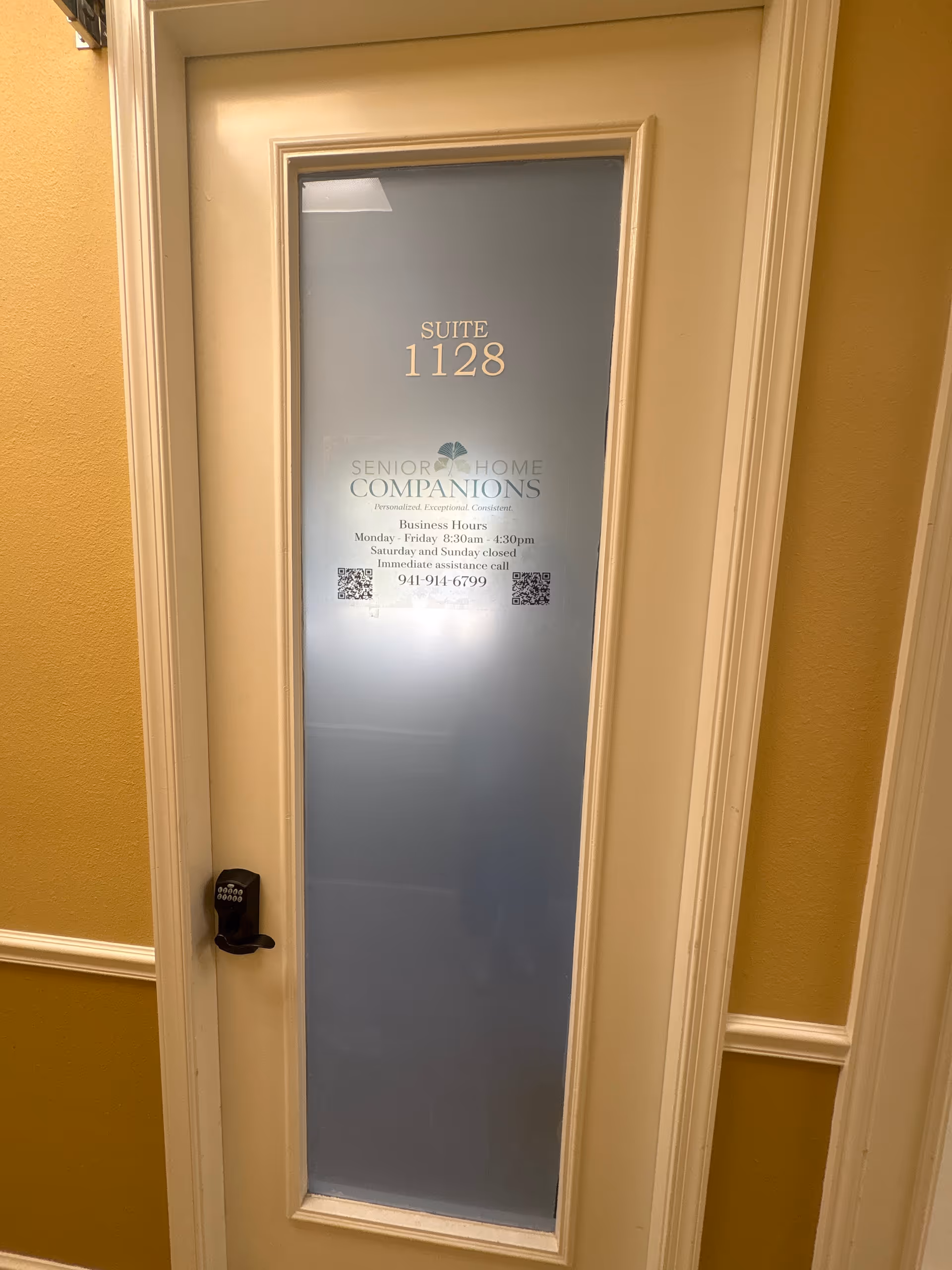 Frosted glass door labeled Suite 1128 with Senior Home Companions signage in hallway.