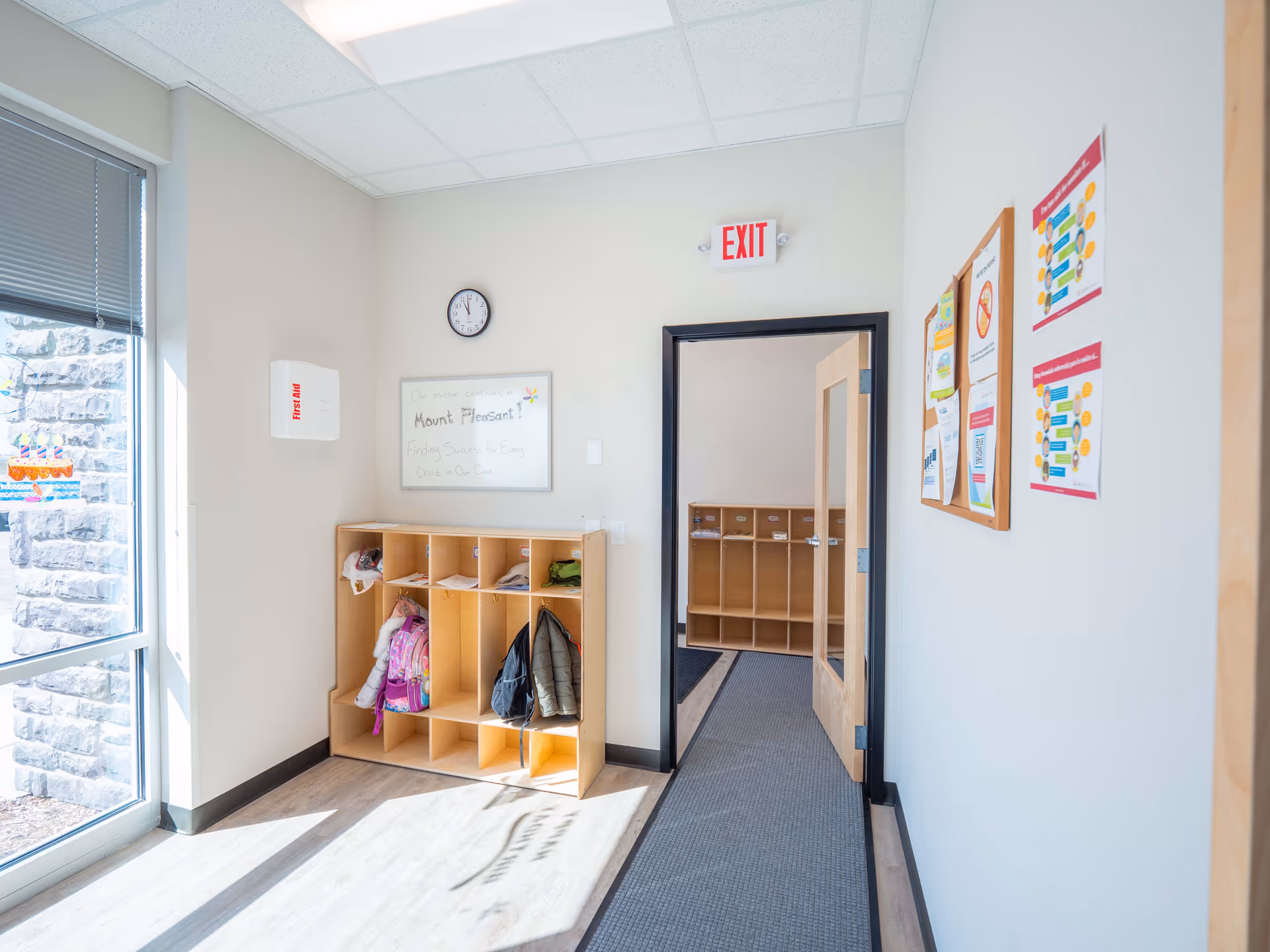 Bright hallway with cubby storage, coats, and bulletin boards