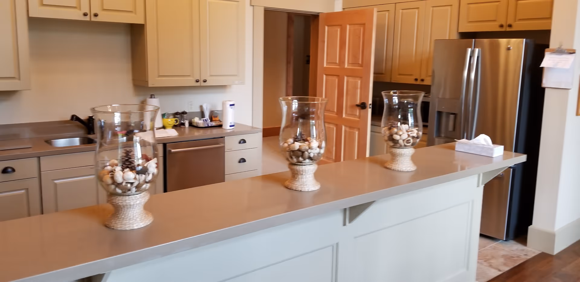 Bright, modern kitchen with light cabinets, a long island, and stainless appliances.