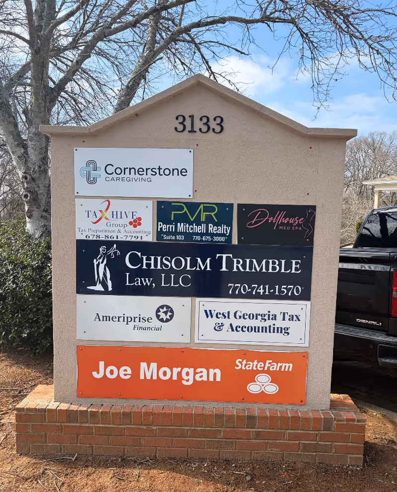 Outdoor monument sign with Cornerstone Caregiving and other business logos on a brick base.