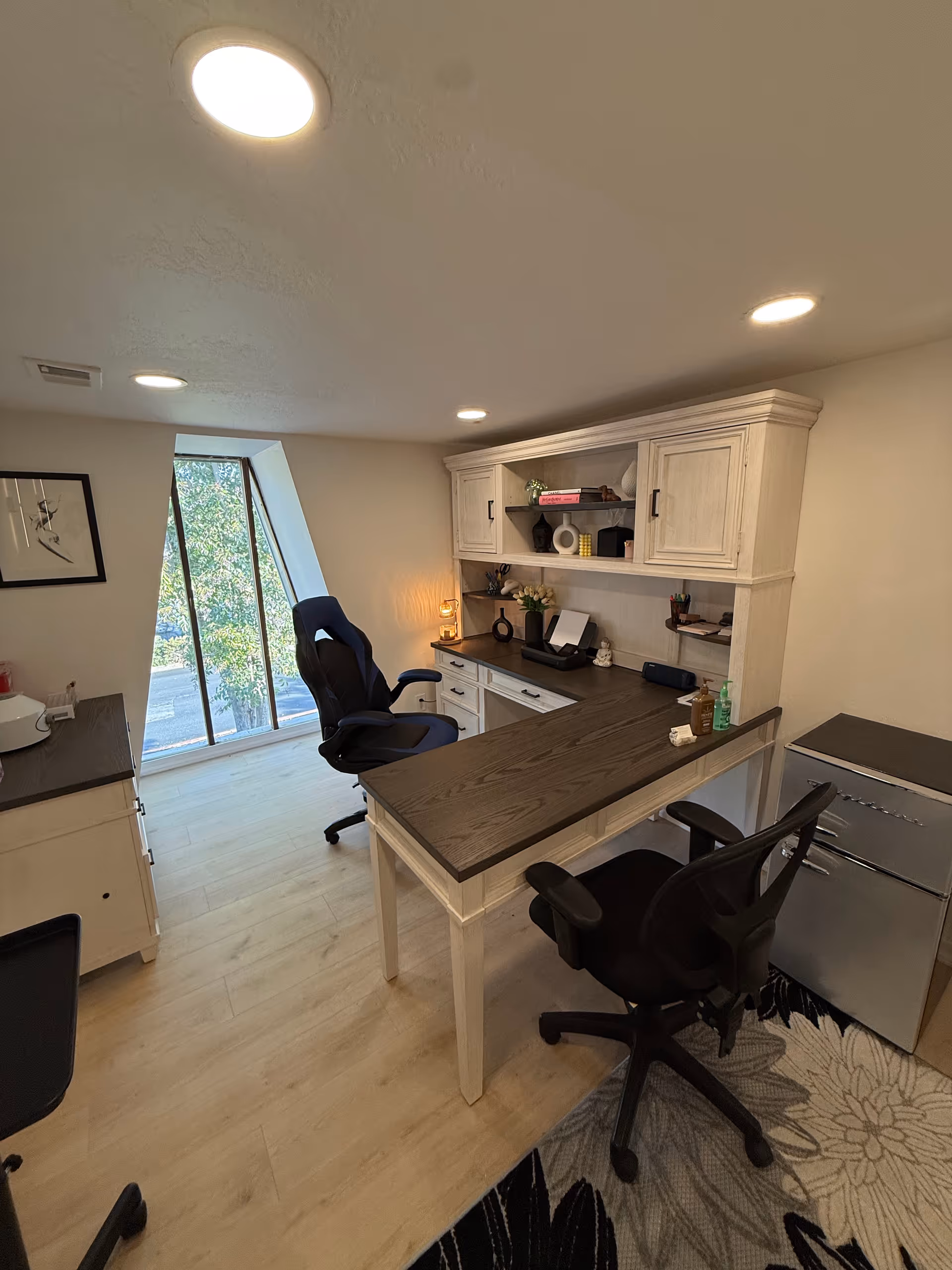 Bright office area with desk, chairs, and shelves in a senior living facility.
