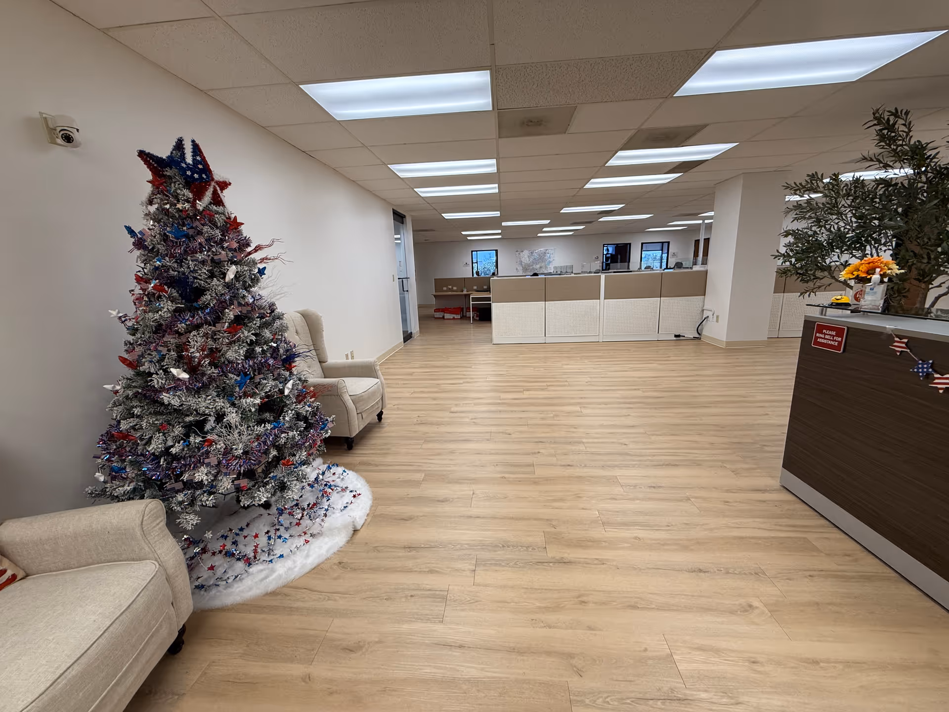 Spacious interior lobby with a Christmas tree, beige seating, and a reception desk.