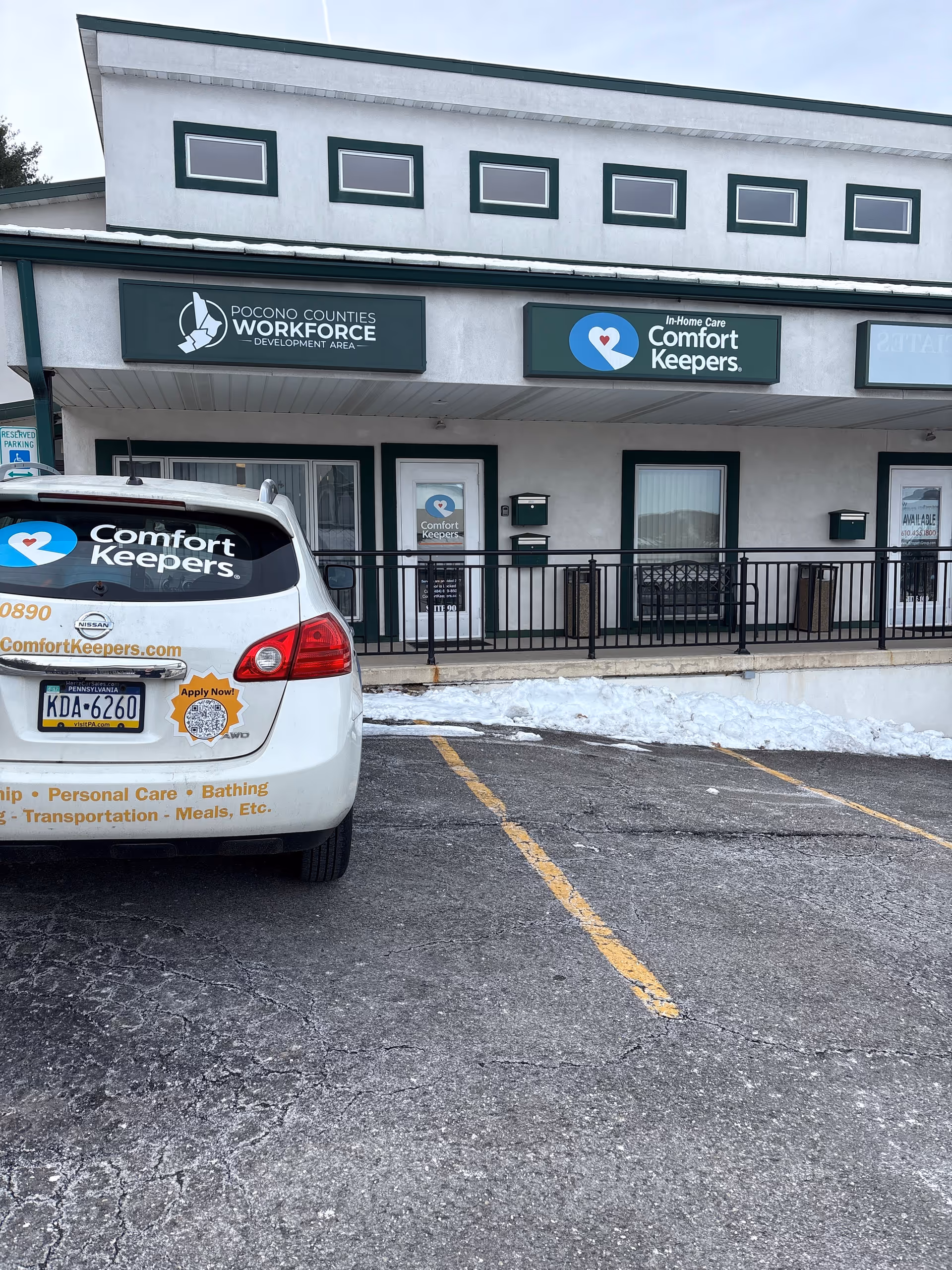 Exterior view of Comfort Keepers storefront with a branded car parked in front.
