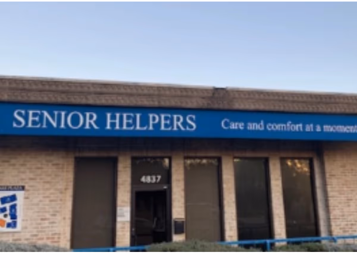 Exterior of a Senior Helpers building with blue sign and brick facade.