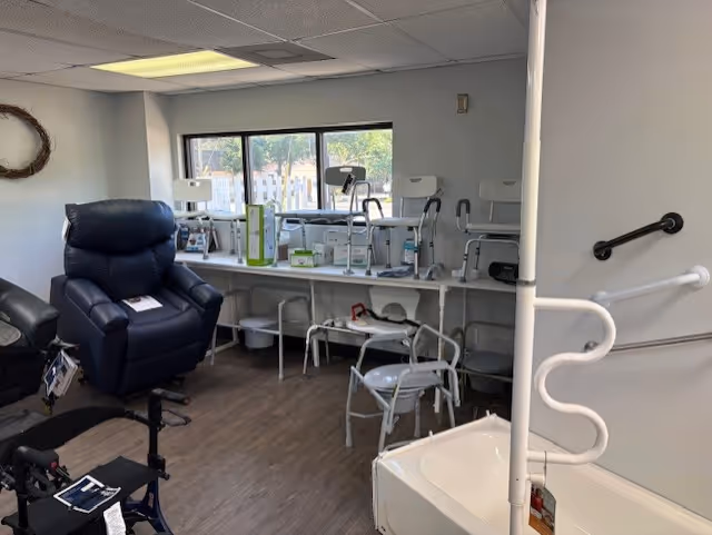 Interior therapy room with medical chairs, a blue recliner, and a bathtub with rails.