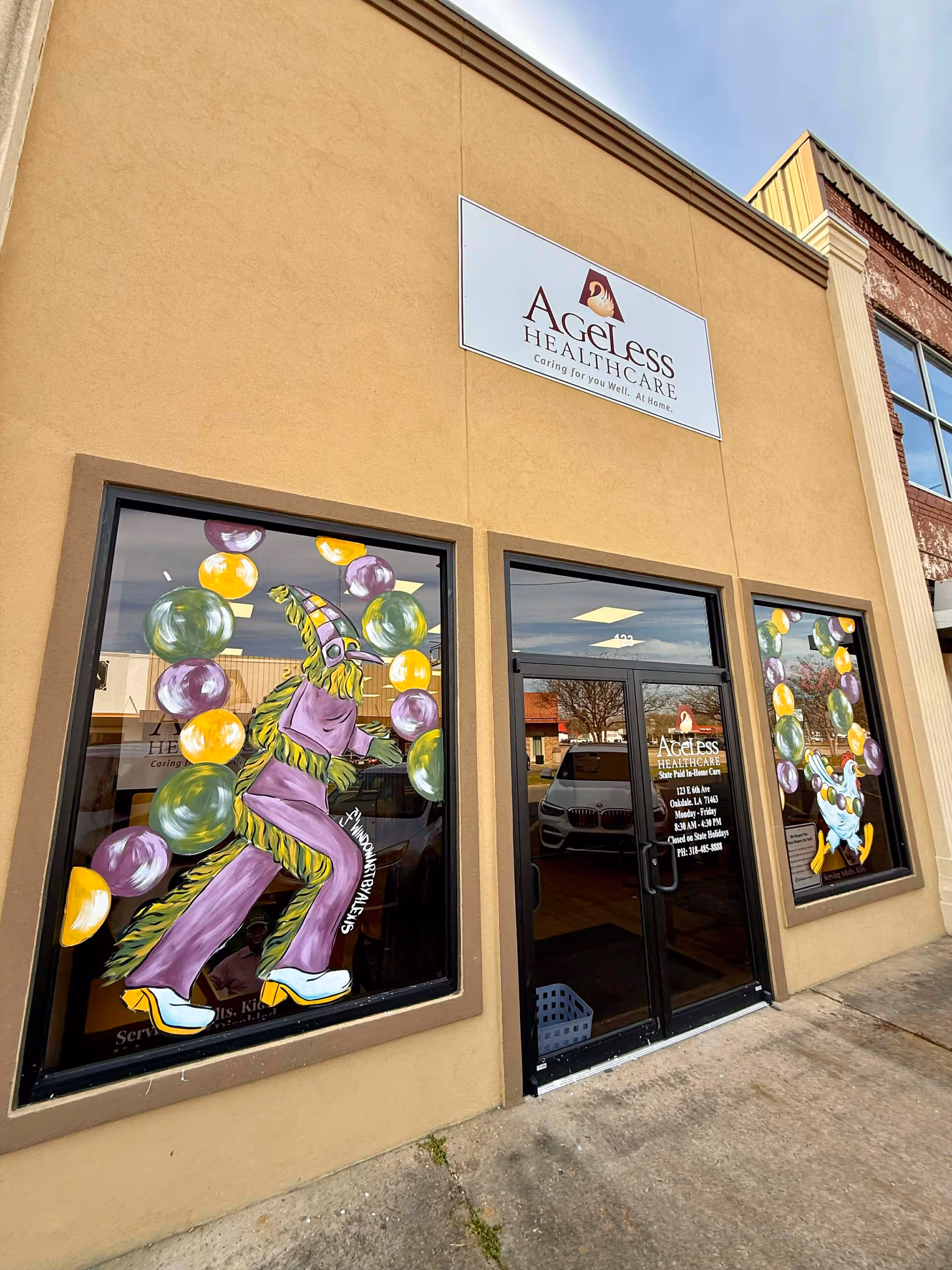 Exterior view of Ageless Healthcare storefront with colorful window murals and the entrance door.