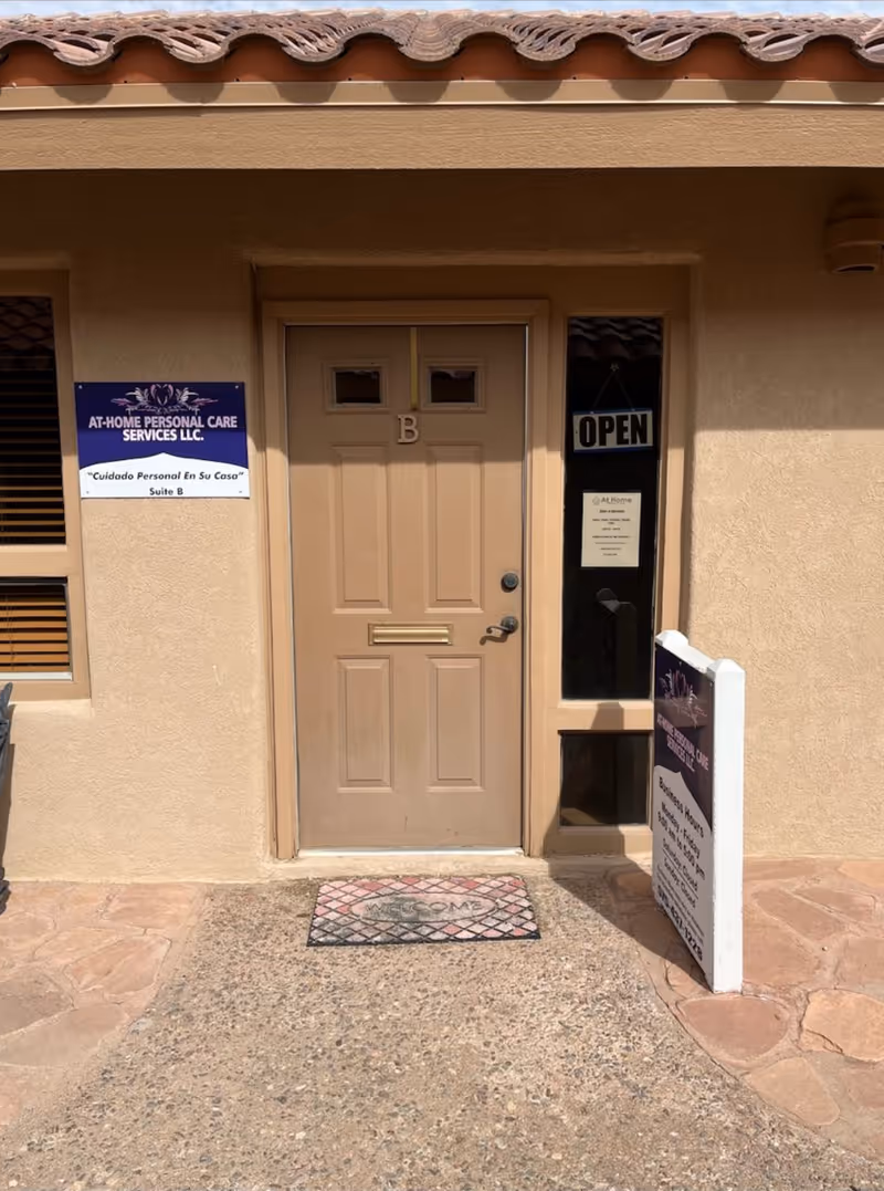 Beige building exterior with a front door labeled B, open sign, and business signage.