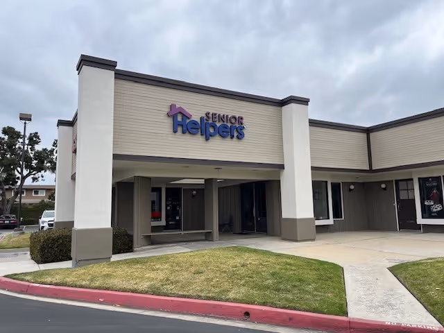 Front view of a Senior Helpers facility with sign, entrance, and parking area.