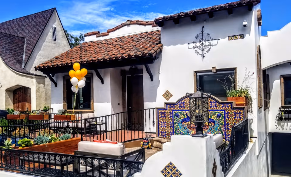 Exterior courtyard of Raya's Paradise with white stucco walls, terracotta roof tiles, and outdoor seating.