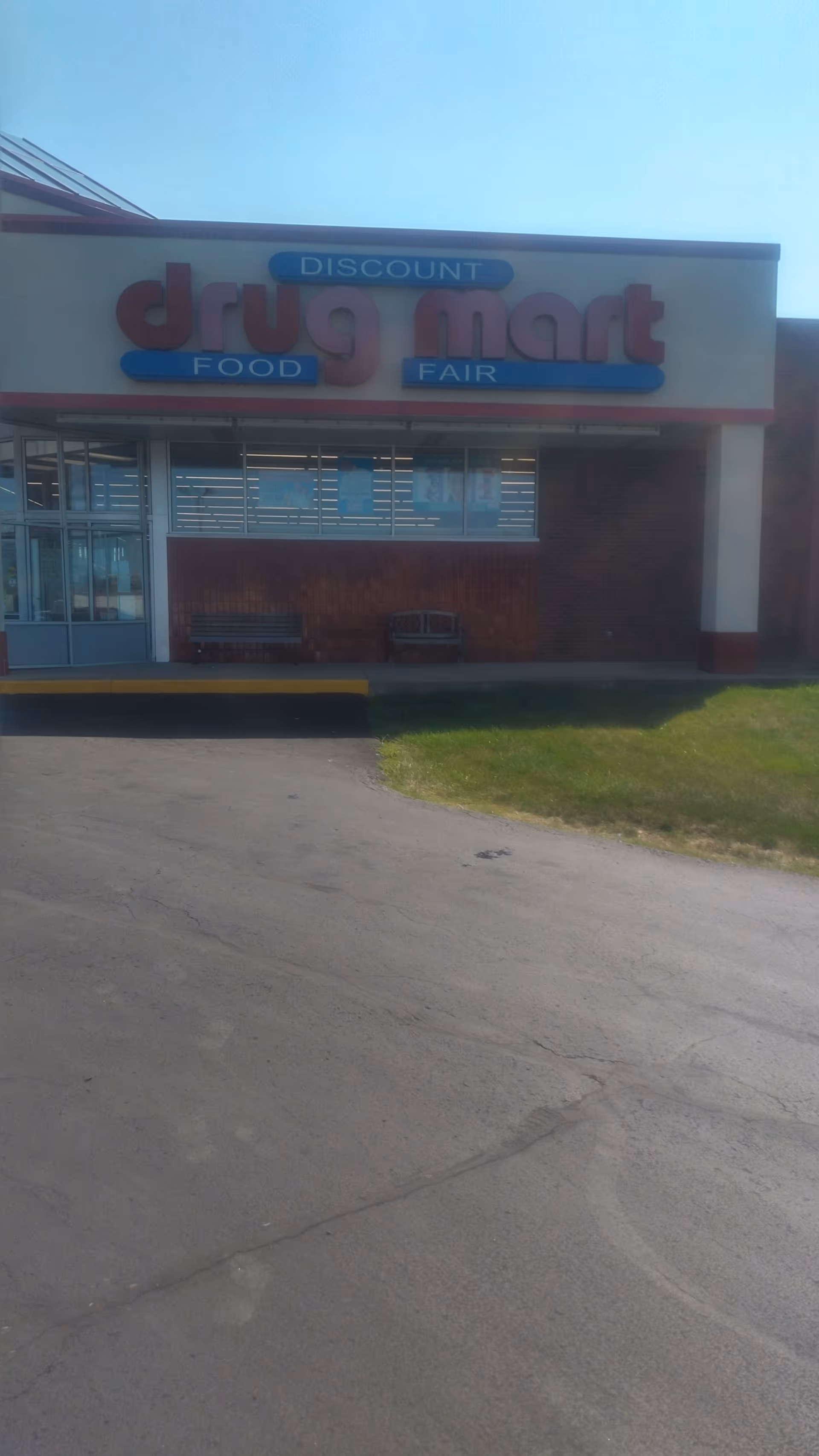 Exterior view of a Discount Drug Mart storefront with large sign and brick facade.