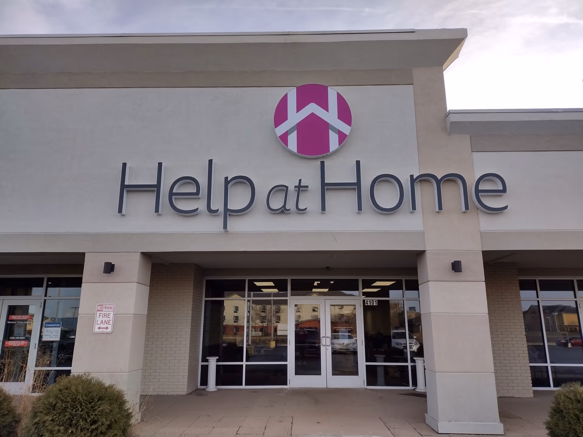Front facade of Help at Home senior living facility with glass entrance doors.