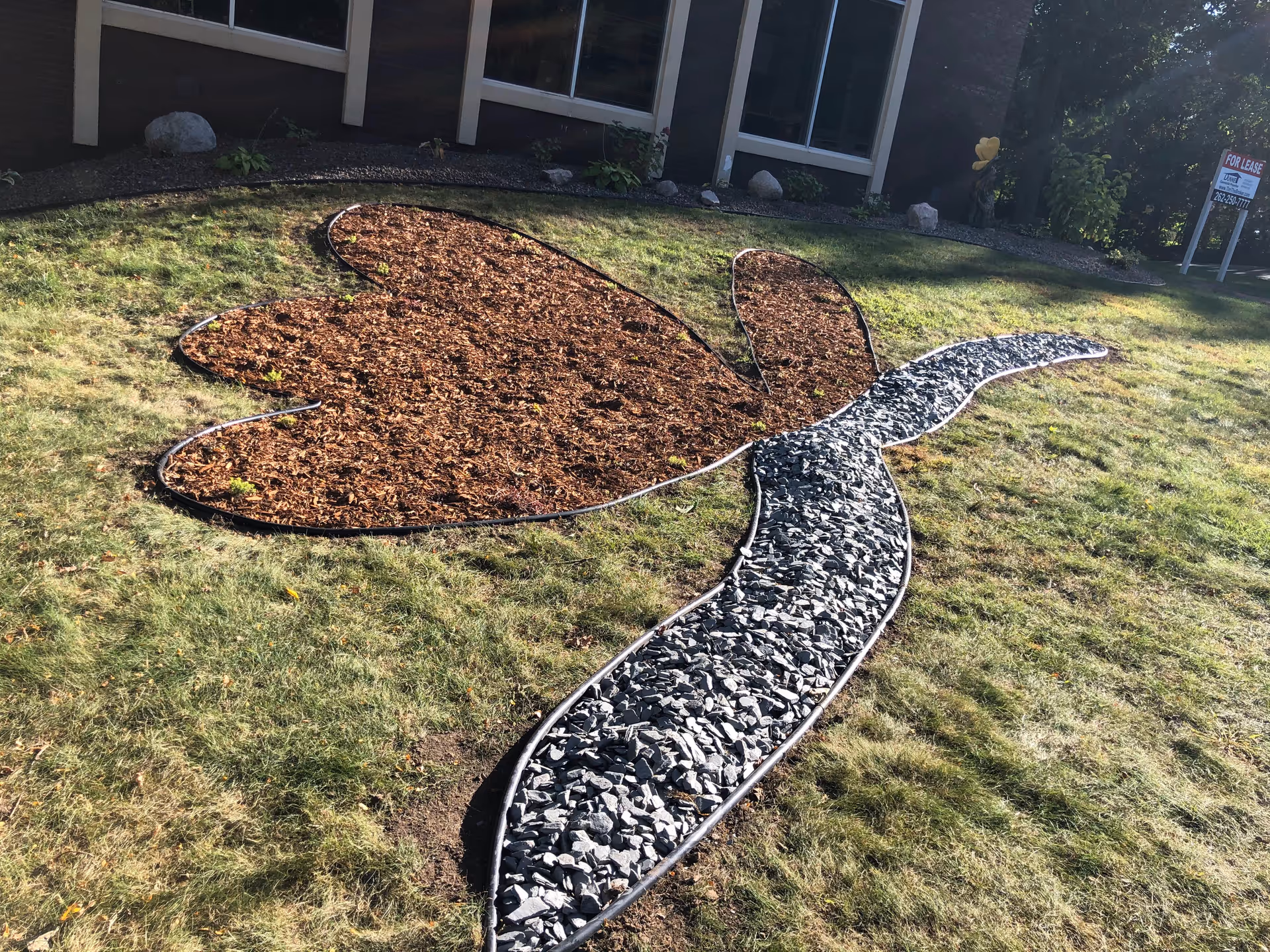 Exterior of Legacy Hospice with a butterfly-shaped rock garden path on the lawn.