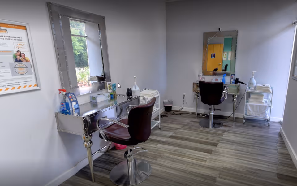 Interior salon area with two styling stations, mirrors, chairs, and supplies.
