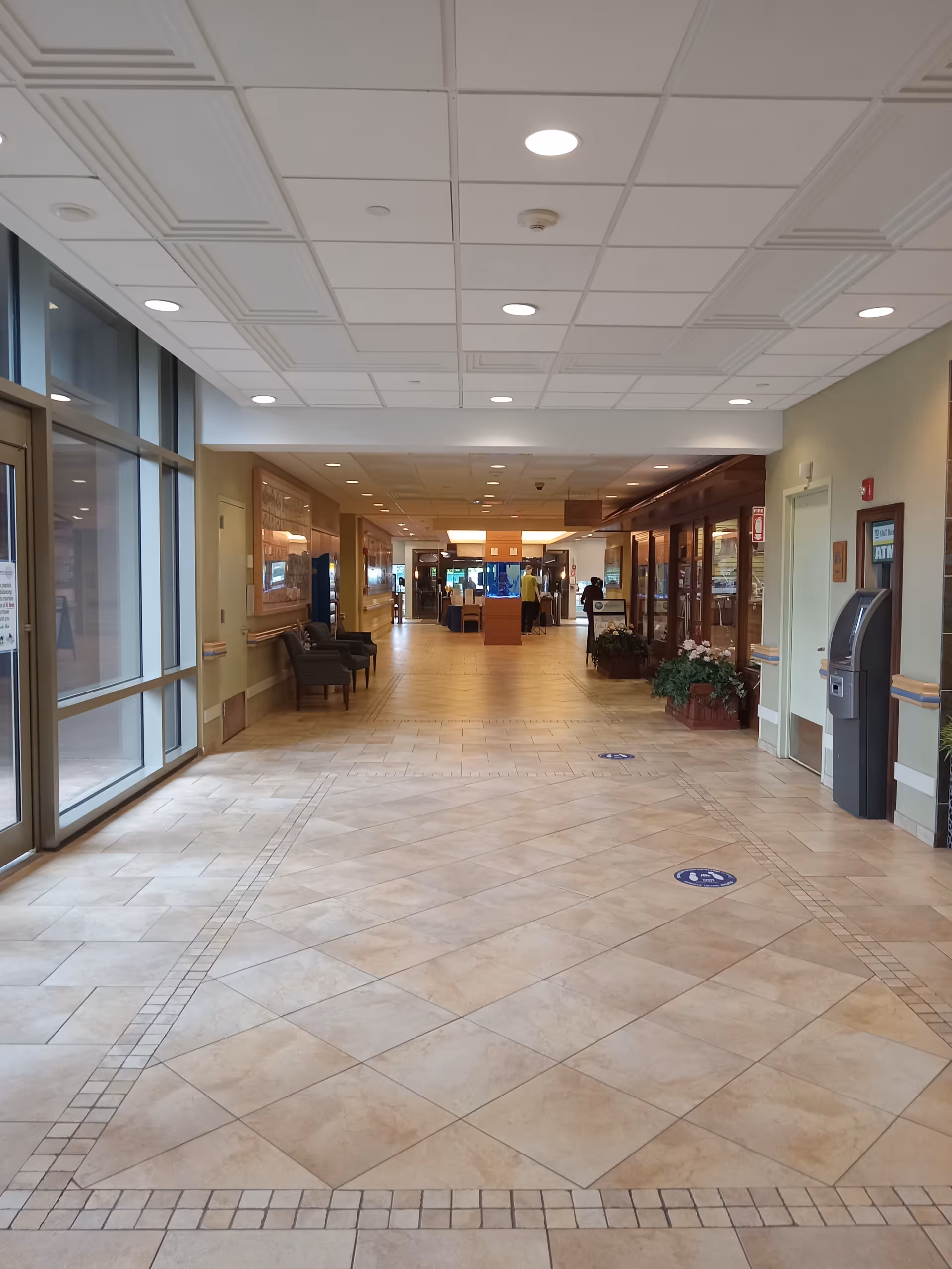 Bright indoor hospital-like hallway at Parker Jewish Institute with seating and plants.