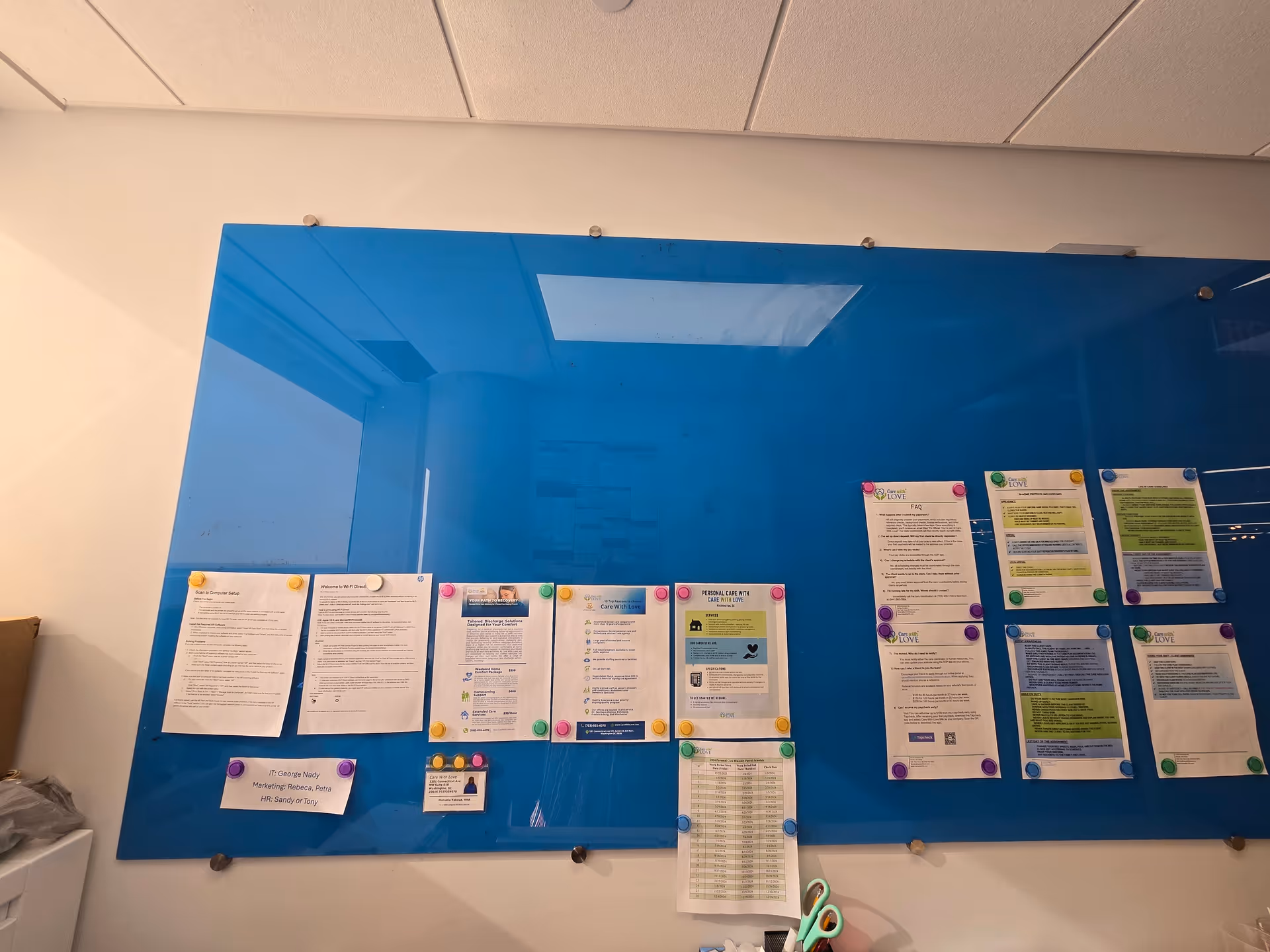Blue bulletin board with various papers pinned in a senior living facility.
