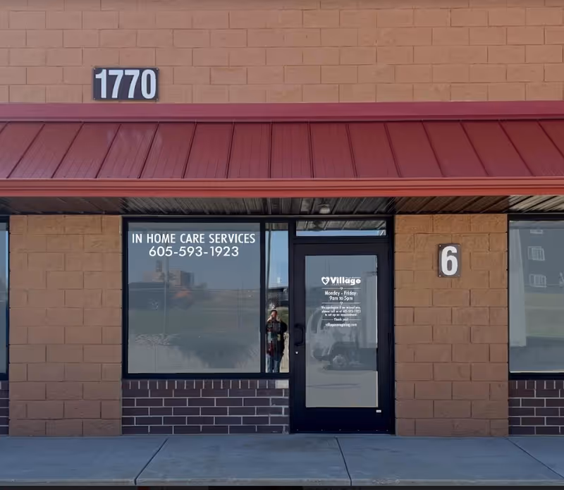 Front exterior of Village Caregiving with door, window signage, and 1770 address.