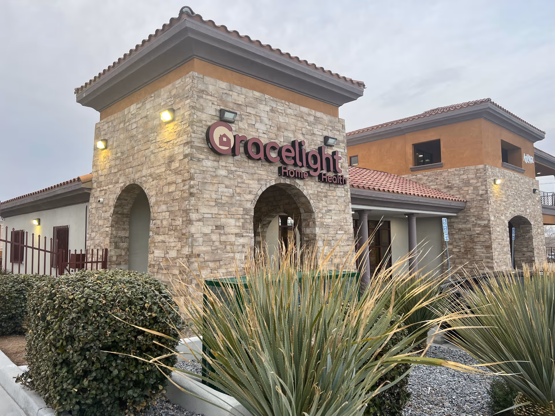 Stone-clad facility exterior with arched entrance and Gracelight Home Health sign.