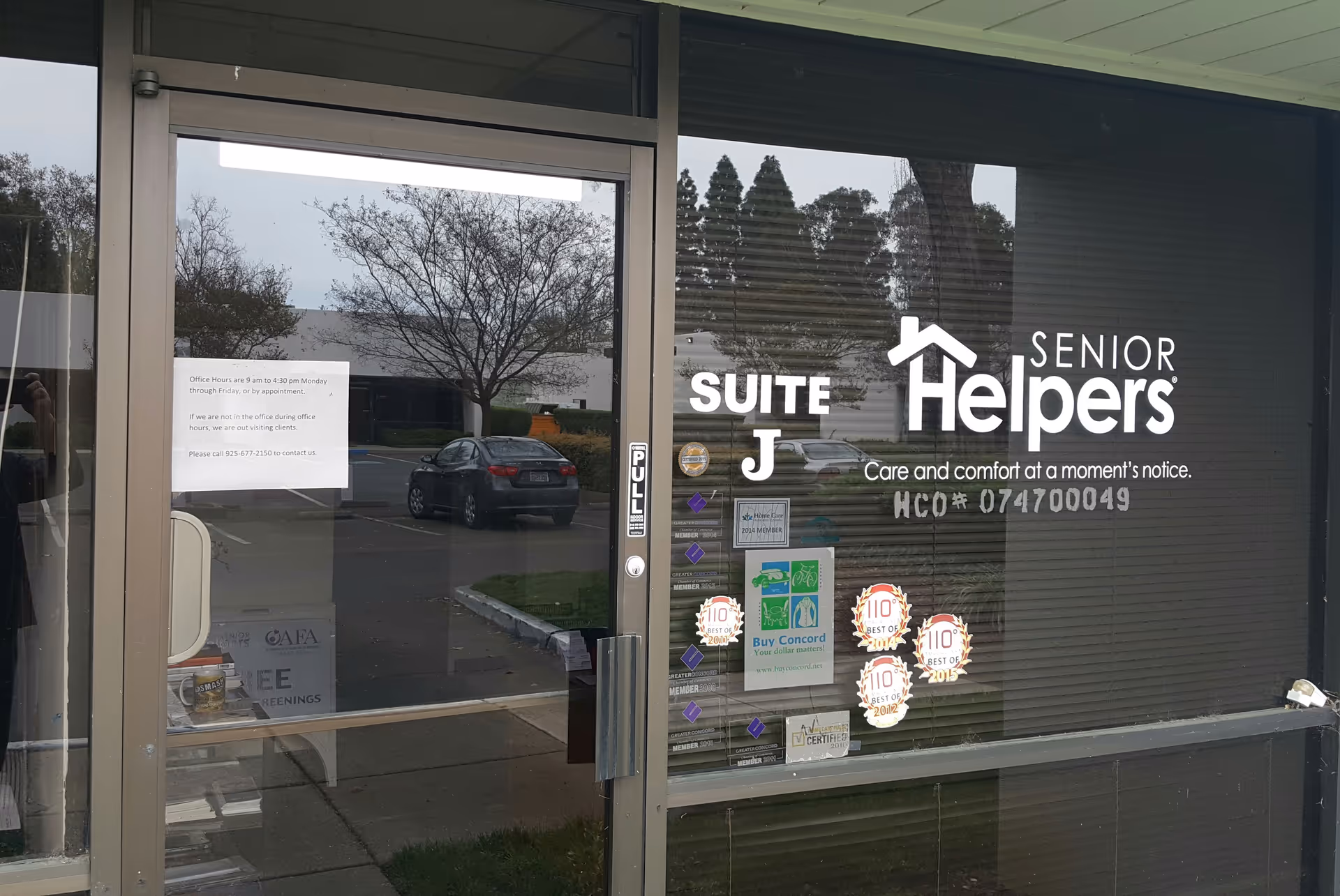 Exterior storefront with Senior Helpers logo on glass door and entrance signage.