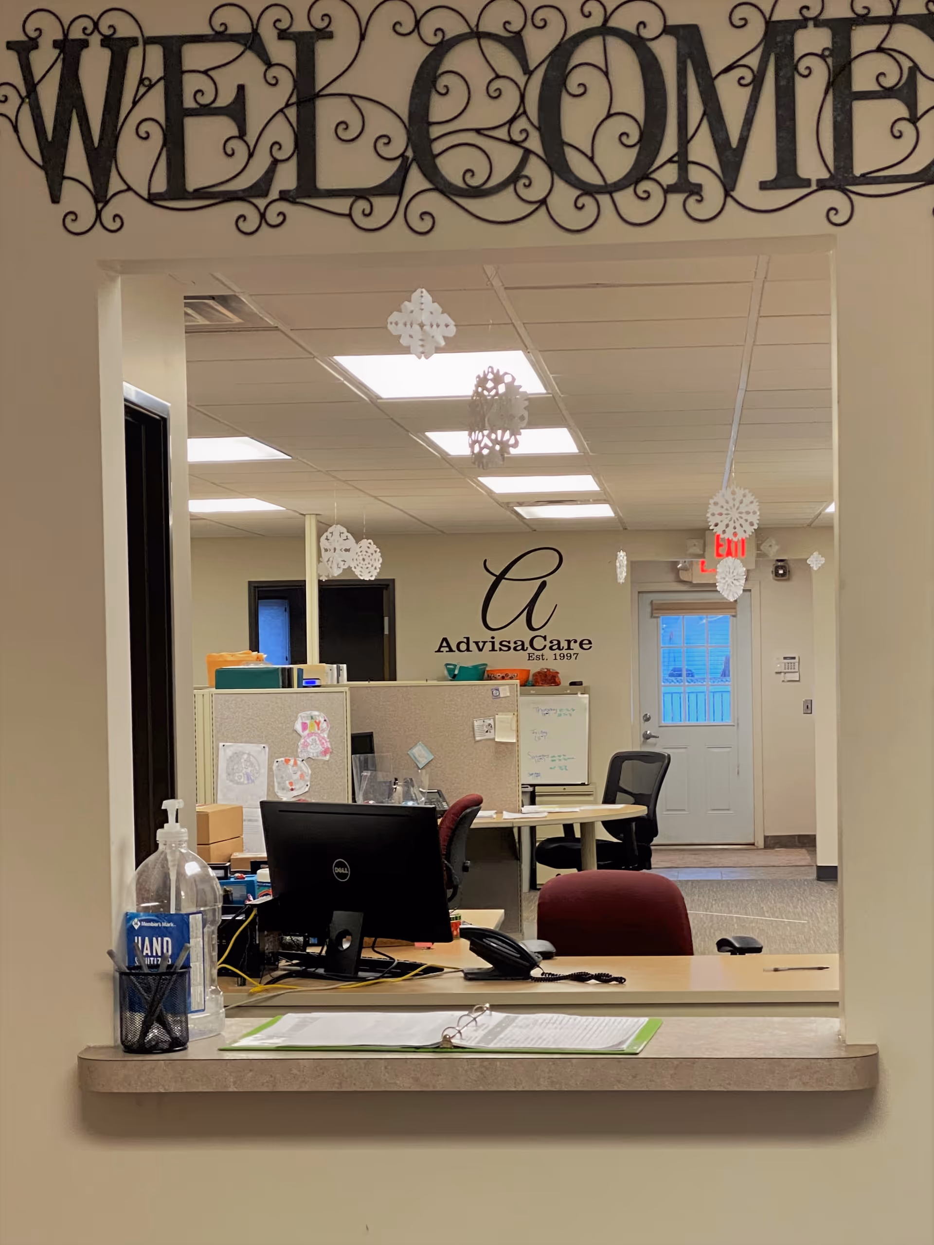 Reception desk at AdvisaCare facility with Welcome signage and winter decorations.