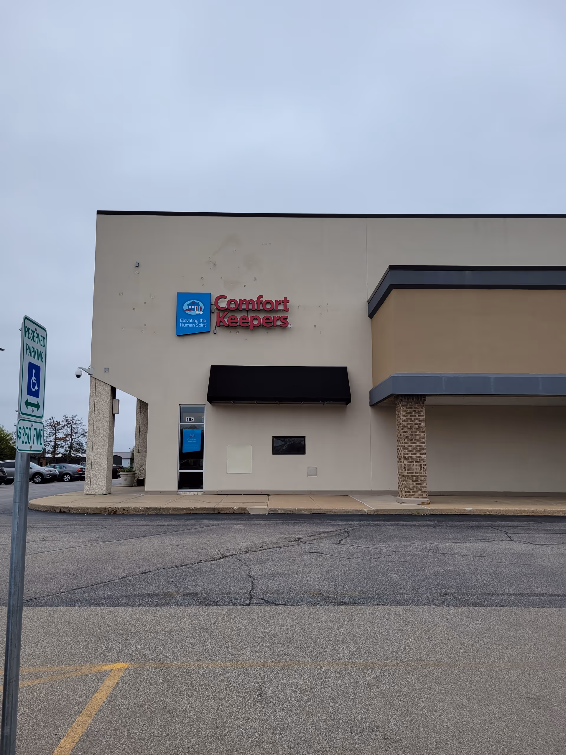 Front view of Comfort Keepers facility with sign, entrance, and parking lot.