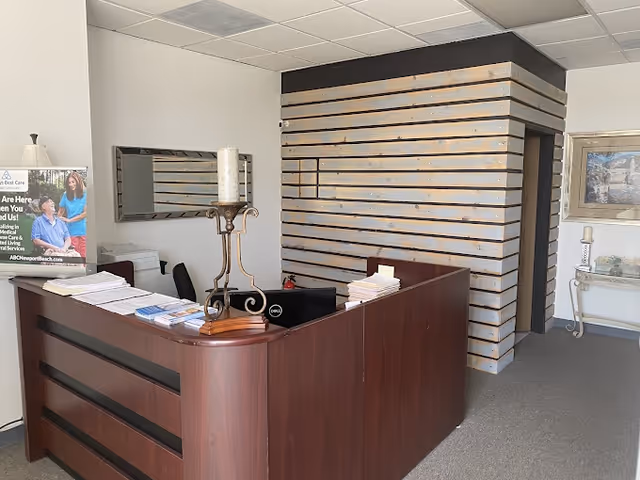 A reception desk in a senior care facility lobby with brochures and a candle centerpiece.
