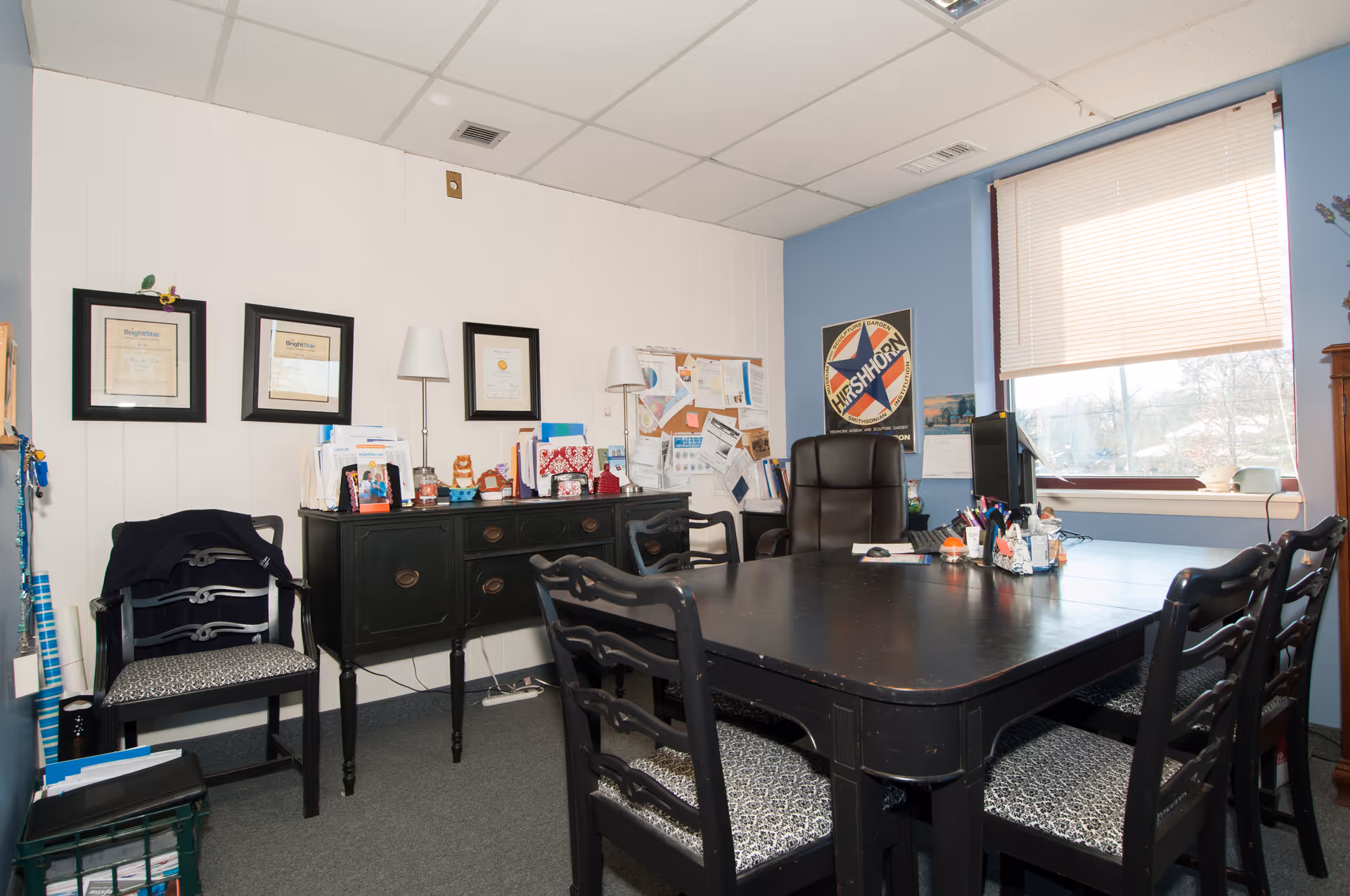 BrightStar Care office with large dark table, chairs, certificates on wall, and bulletin board.