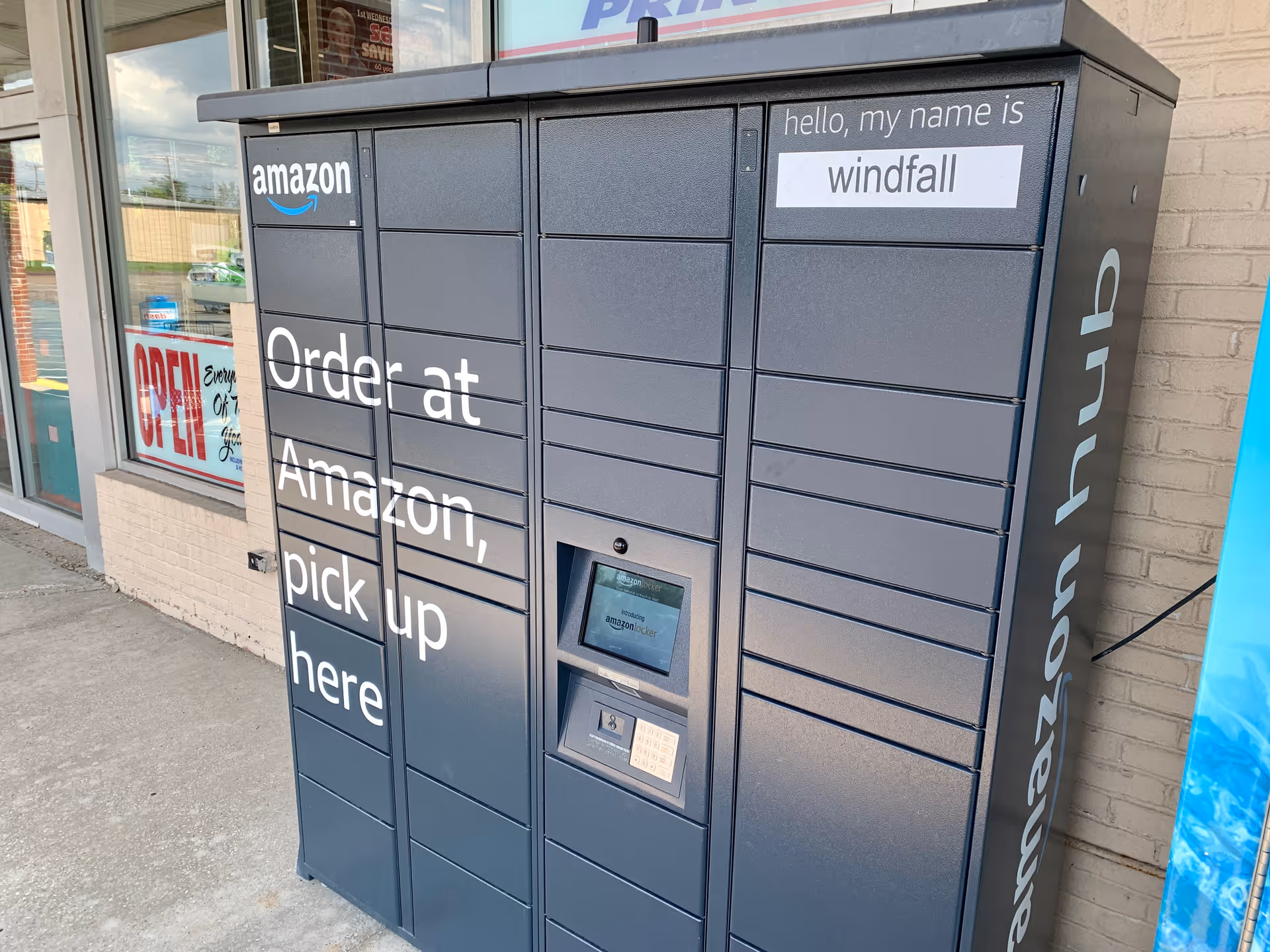 Blue Amazon pickup lockers with 'Order at Amazon, pick up here' outside Discount Drug Mart.