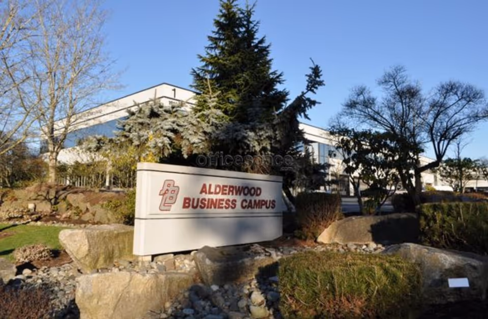 Exterior view of a building with a sign reading Alderwood Business Campus and landscaping.