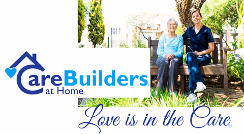 Two people sit on a bench outdoors beside the CareBuilders at Home logo.