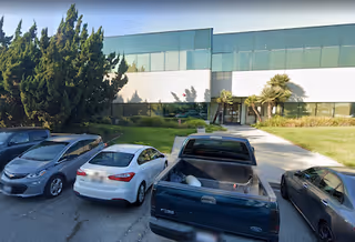 Exterior view of Comfort Keepers Home Care building with parked cars in front.