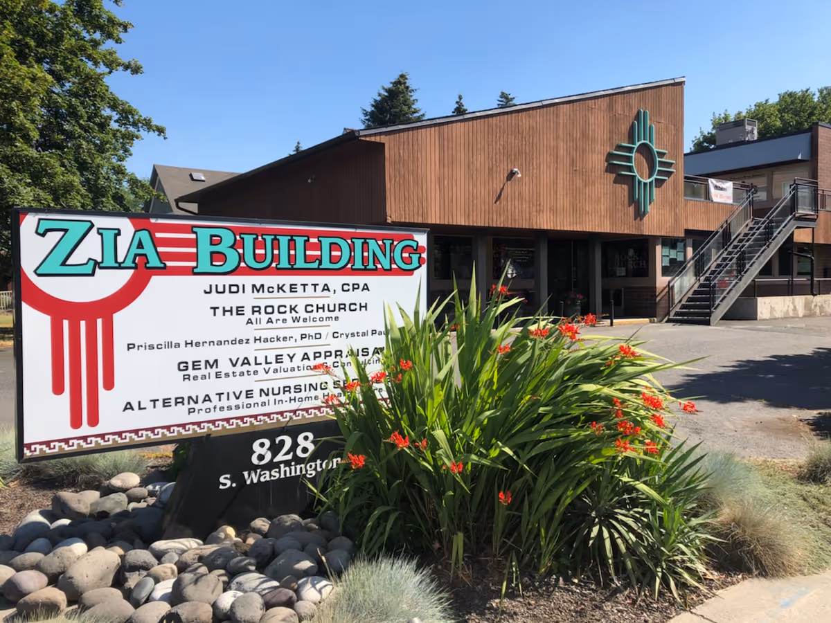 Exterior view of Alternative Nursing Services, Inc. building with ZIA Building sign and landscaping.