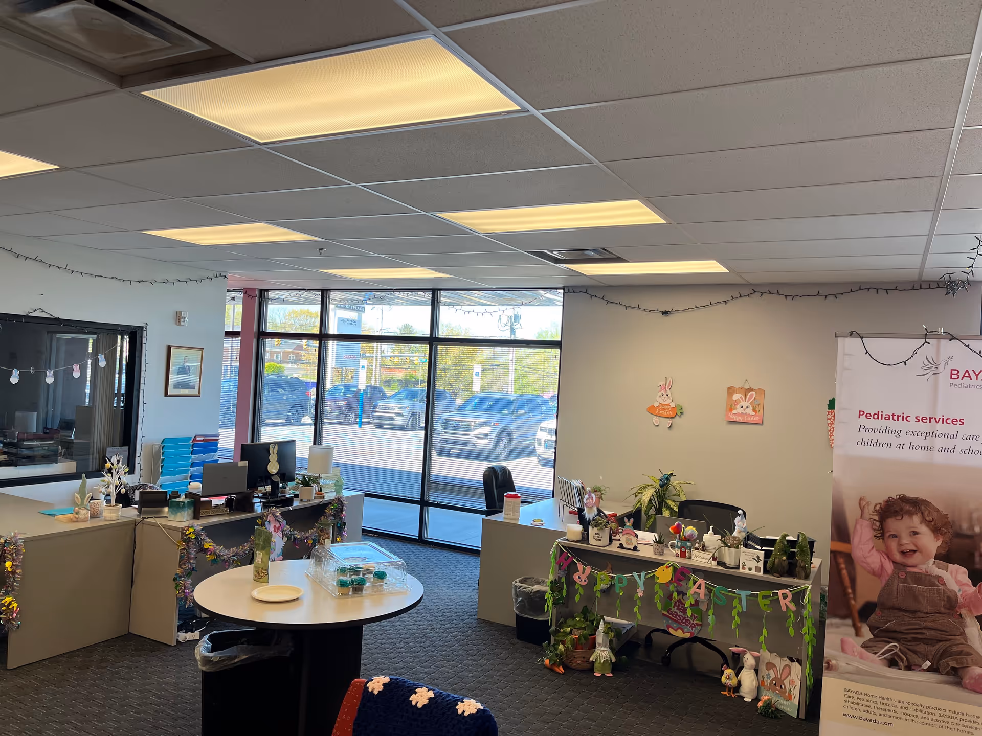 Bright BAYADA Pediatrics reception area with desks, decor, and large windows.